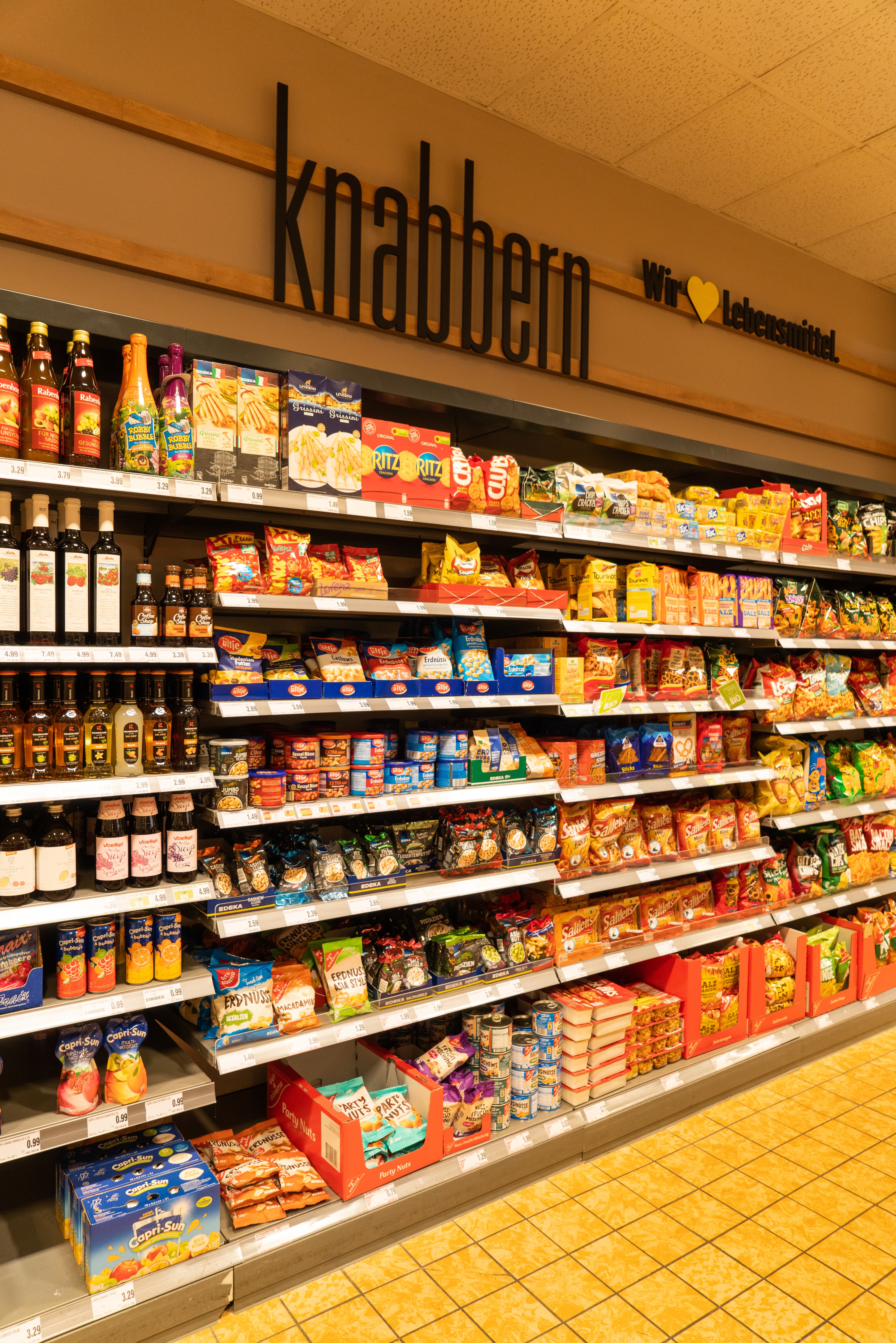 Ein Regal mit der Überschrift "knabbern" in einem Edeka-Markt.