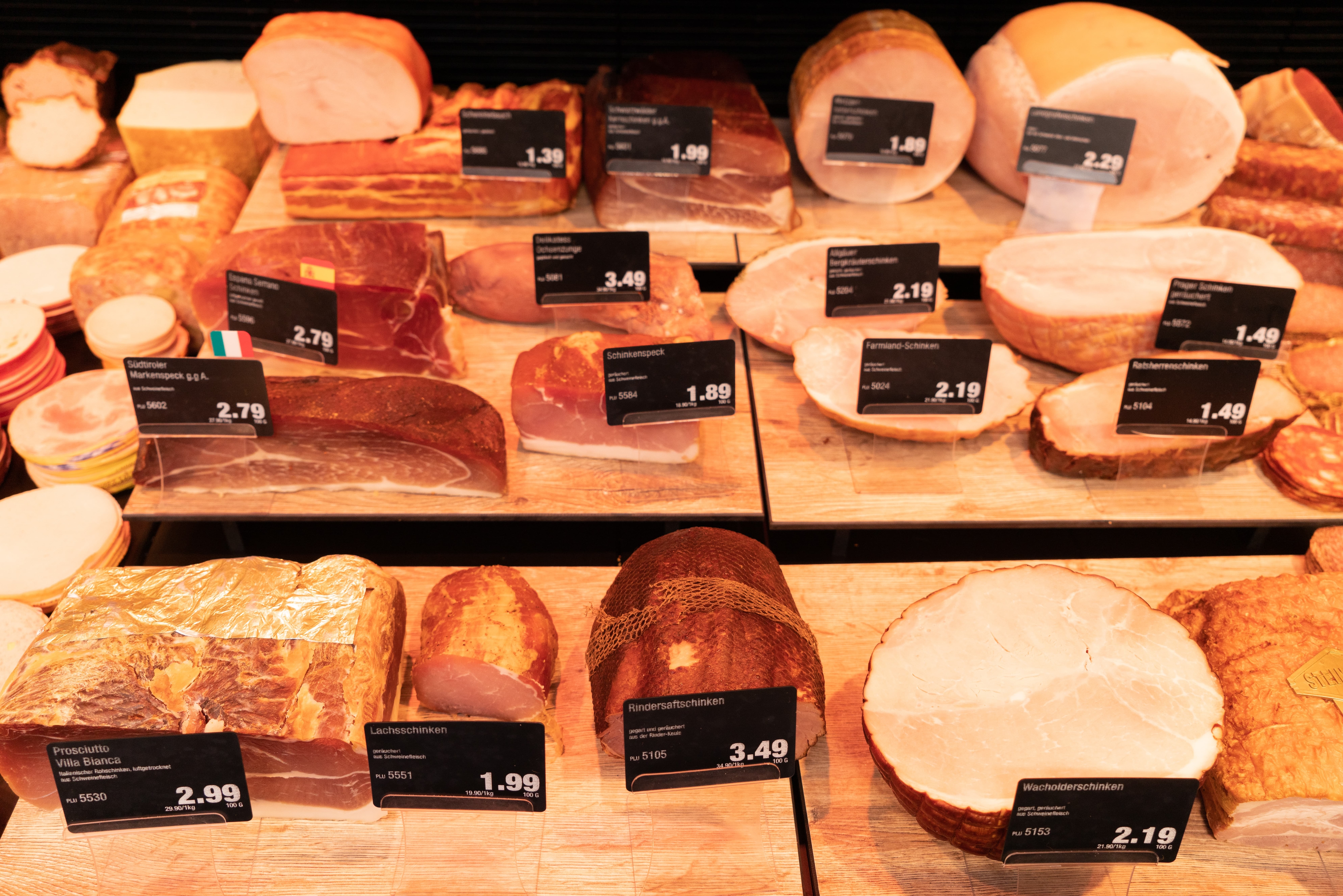 Verschiedene Sorten Schinken in der Frischetheke eines Edekas.
