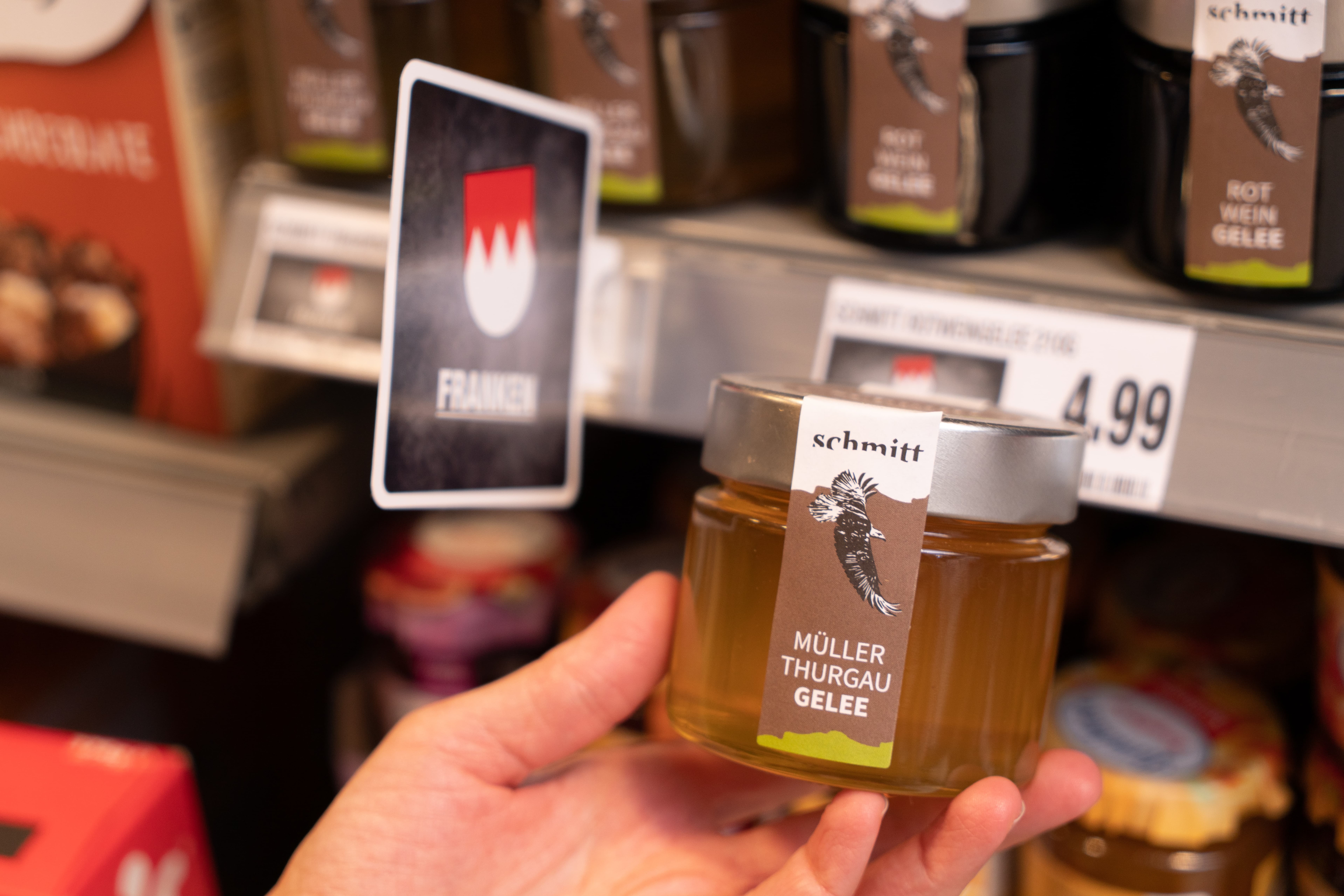 Eine Hand hält ein Glas Gelee aus Franken.