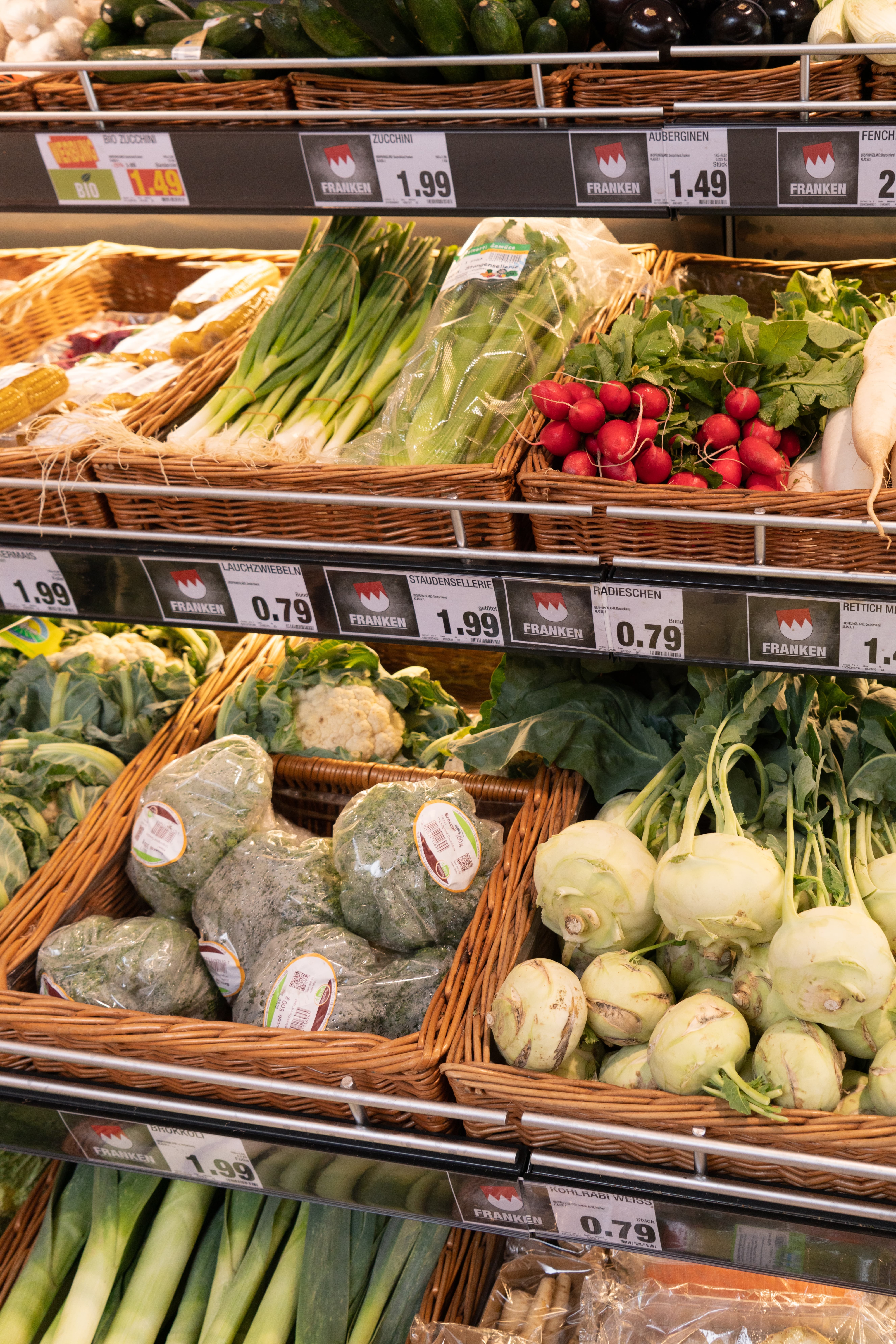 Regale mit Körben gefüllt mit verschiedenen Gemüsesorten.
