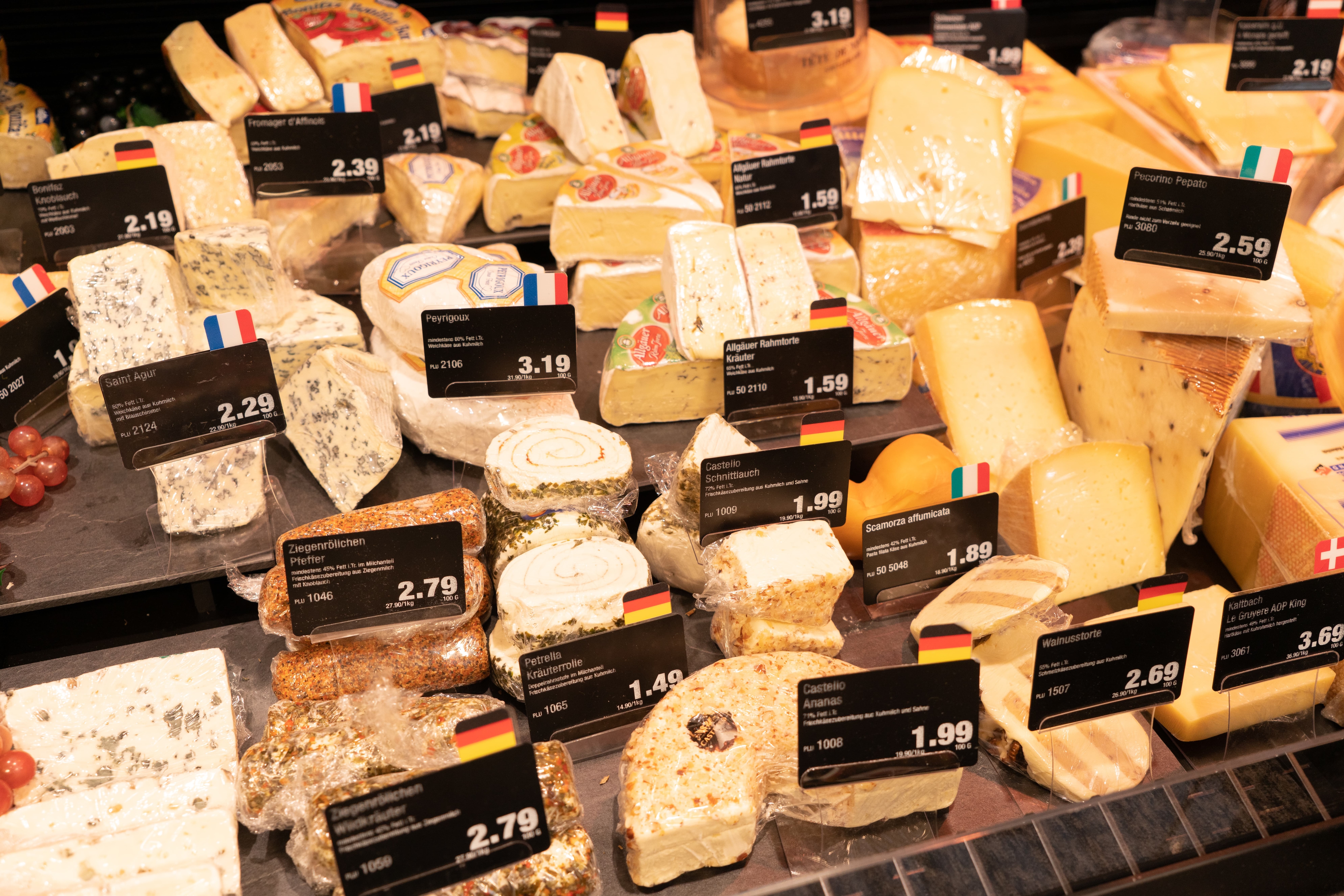 Verschiedene Käsesorten in der Frischetheke eines Edekas.