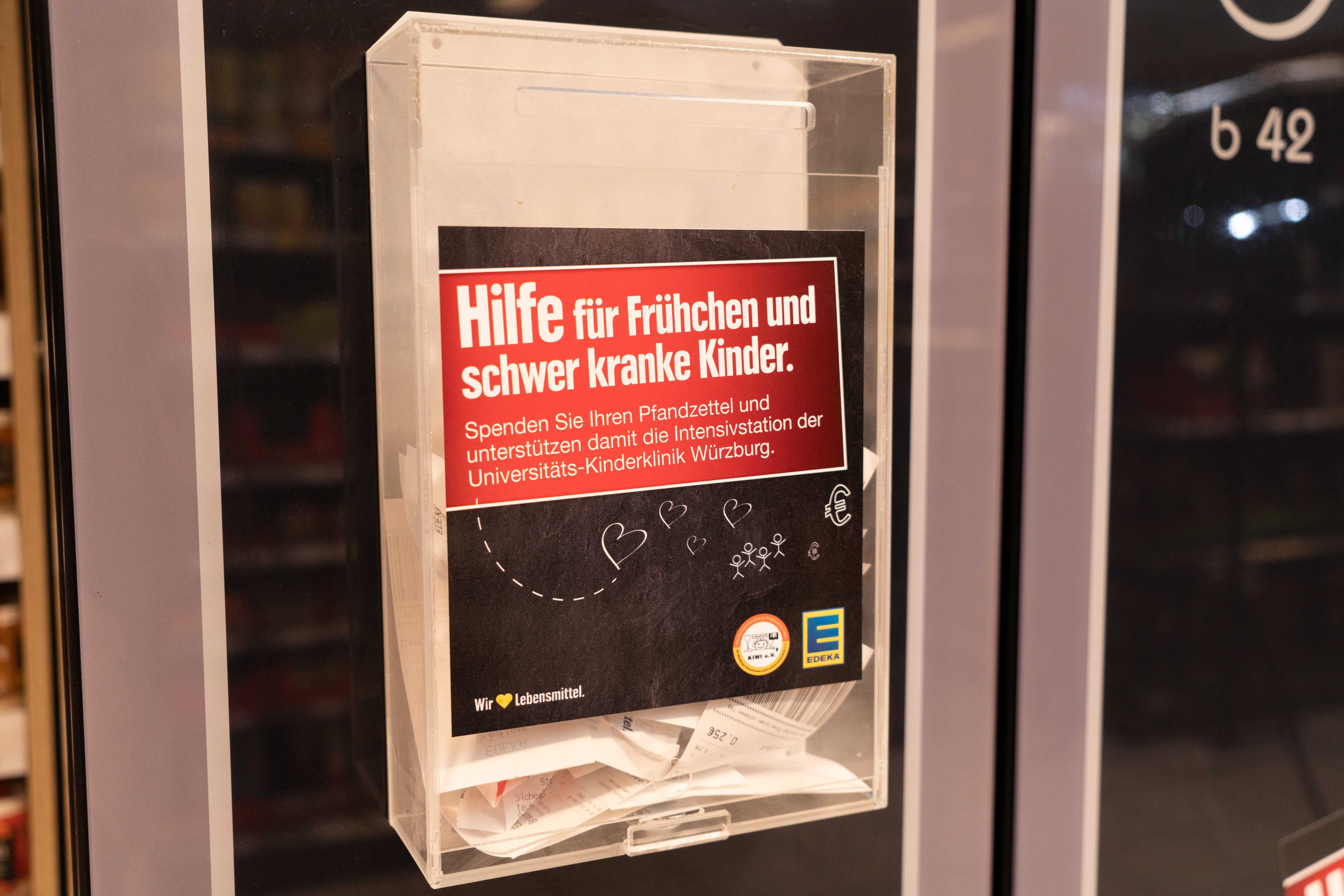 Eine Spendenbox für Pfandbons mit der Aufschrift: "Hilfe für Frühchen und schwer kranke Kinder"