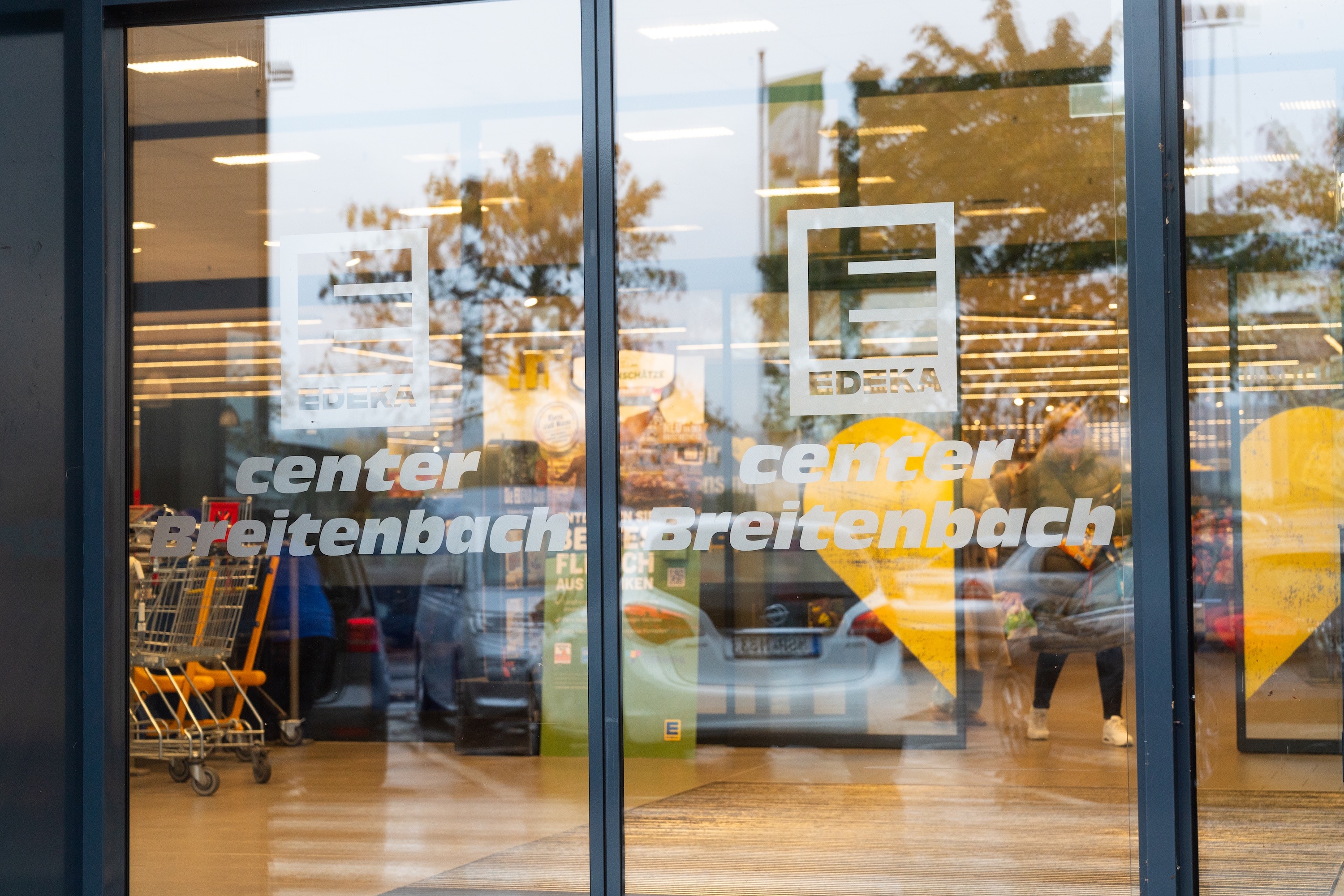 Glastür eines EDEKA-Marktes mit Beschriftung: EDEKA center Breitenbach.