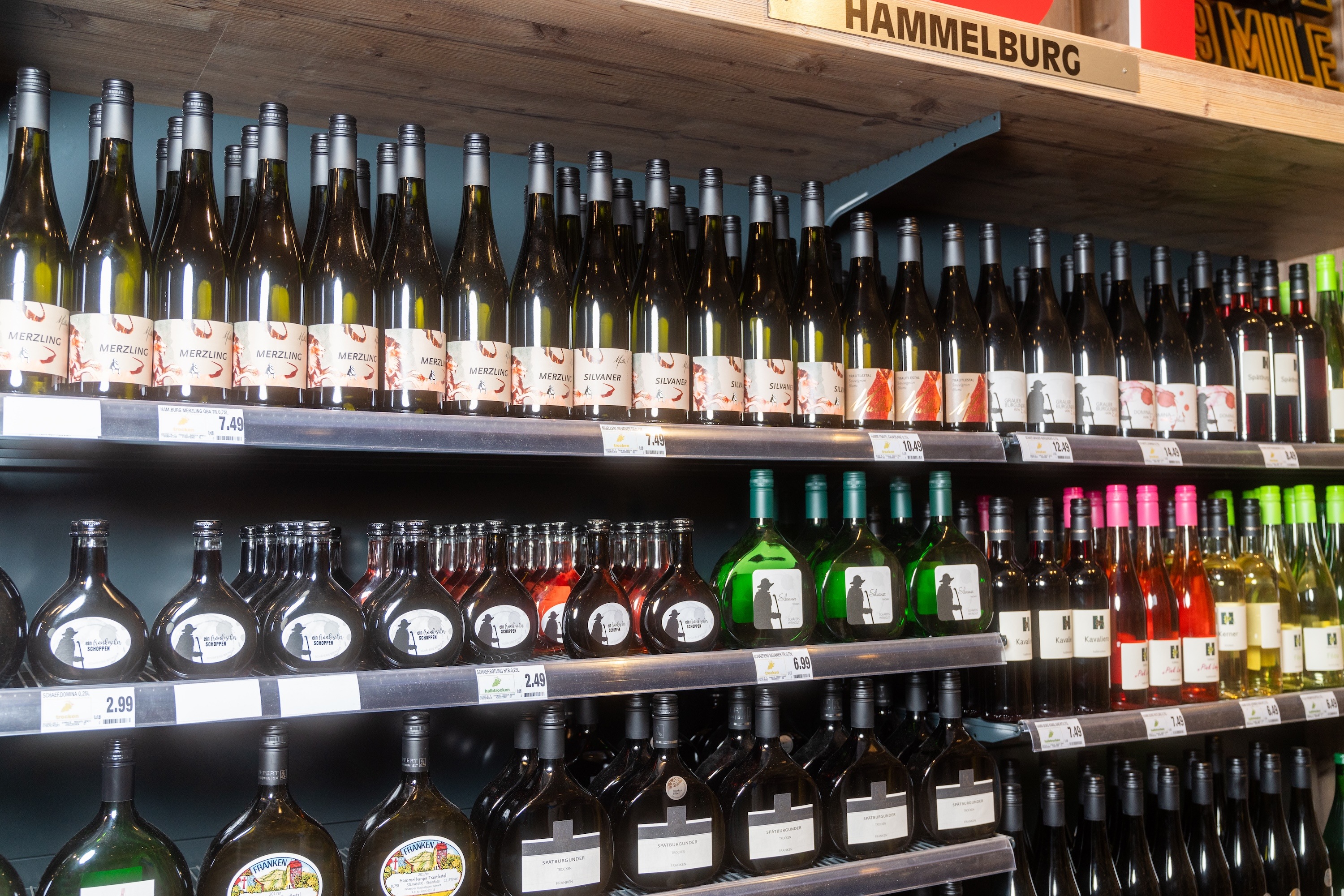 Ein Weinregal über dem Hammelburg geschrieben steht.