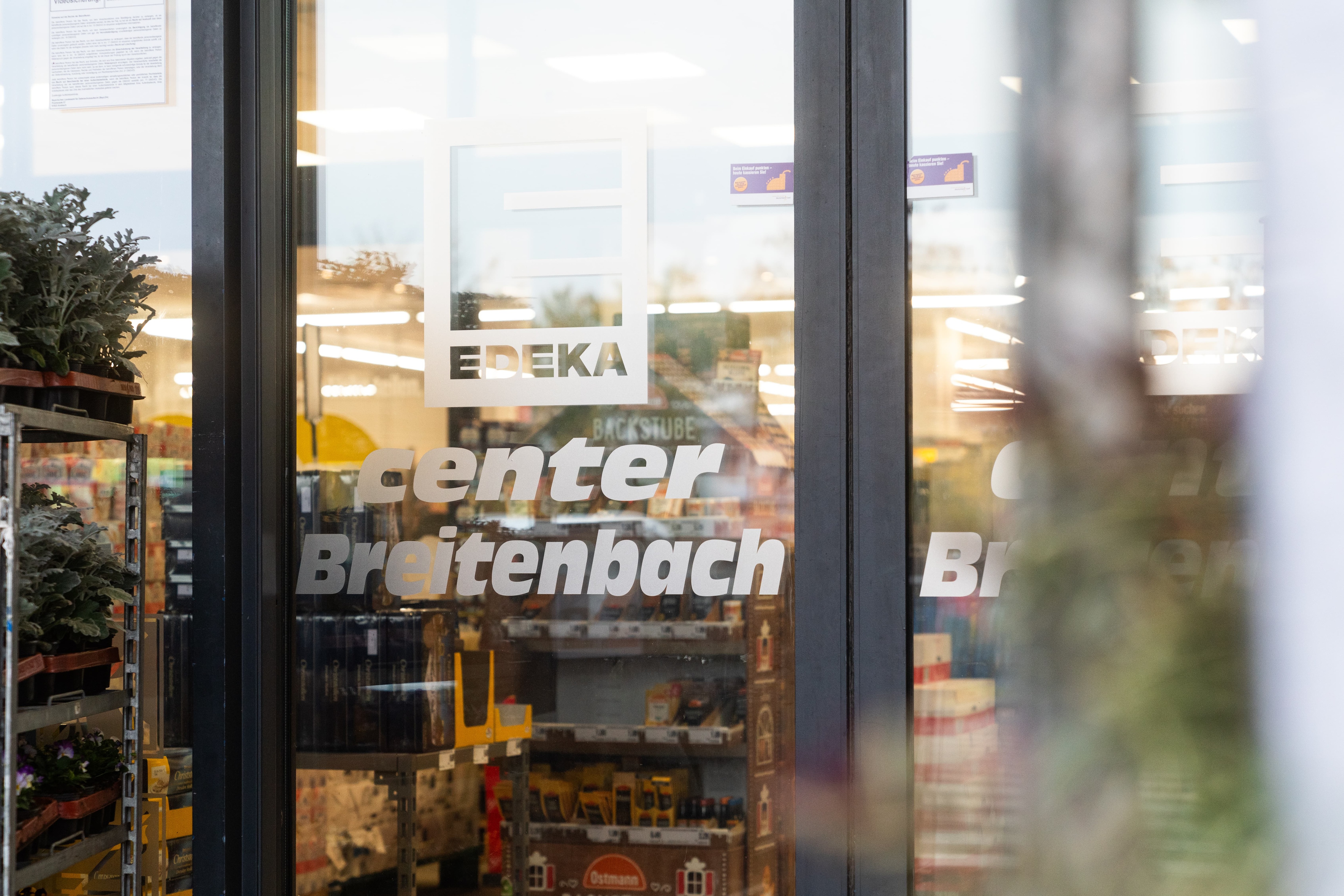 Elektrische Glastür mit Aufschrift: EDEKA center Breitenbach.