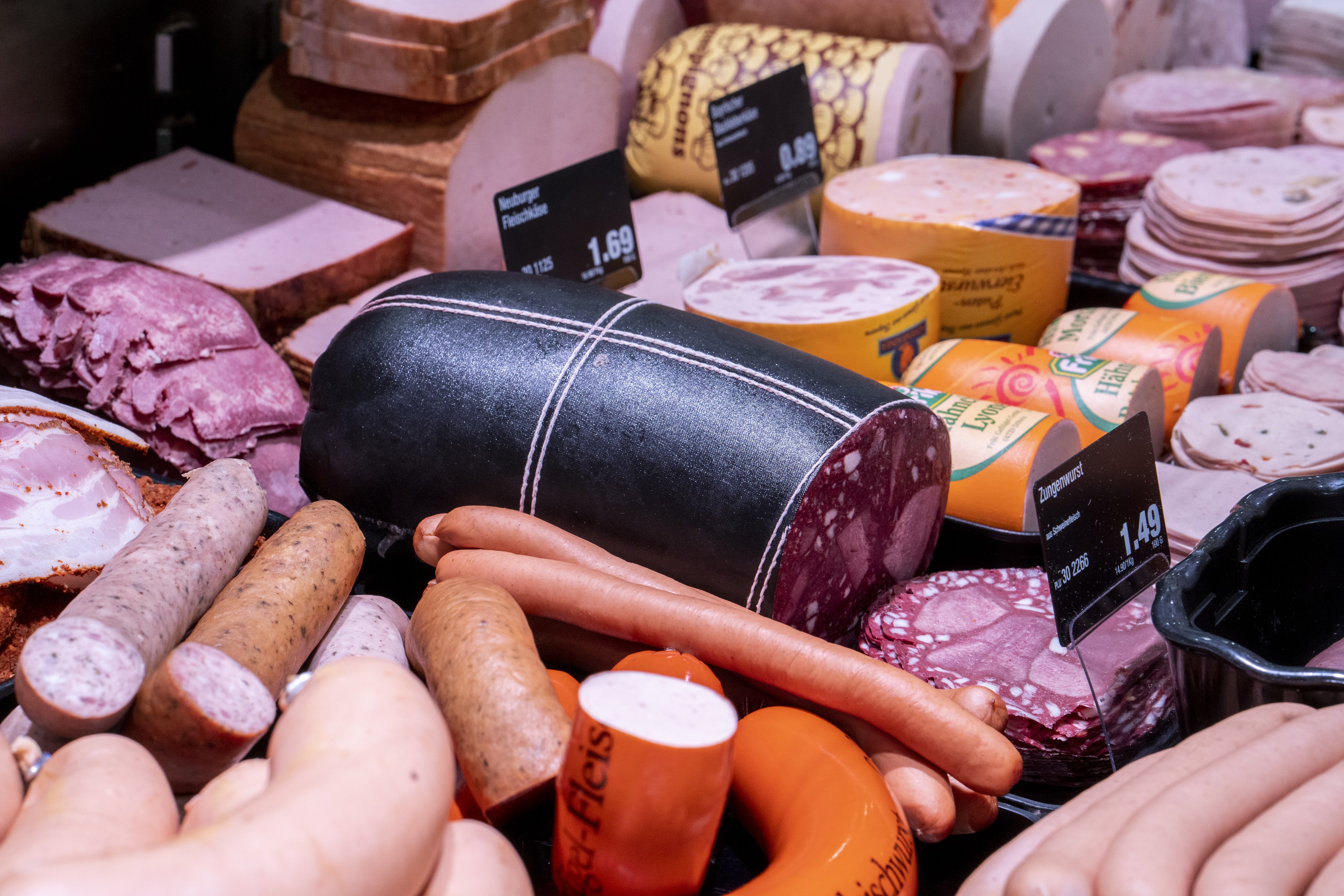 Wurst- und Aufschnittauslage mit unterschiedlichen Produkten und Preisschildern.