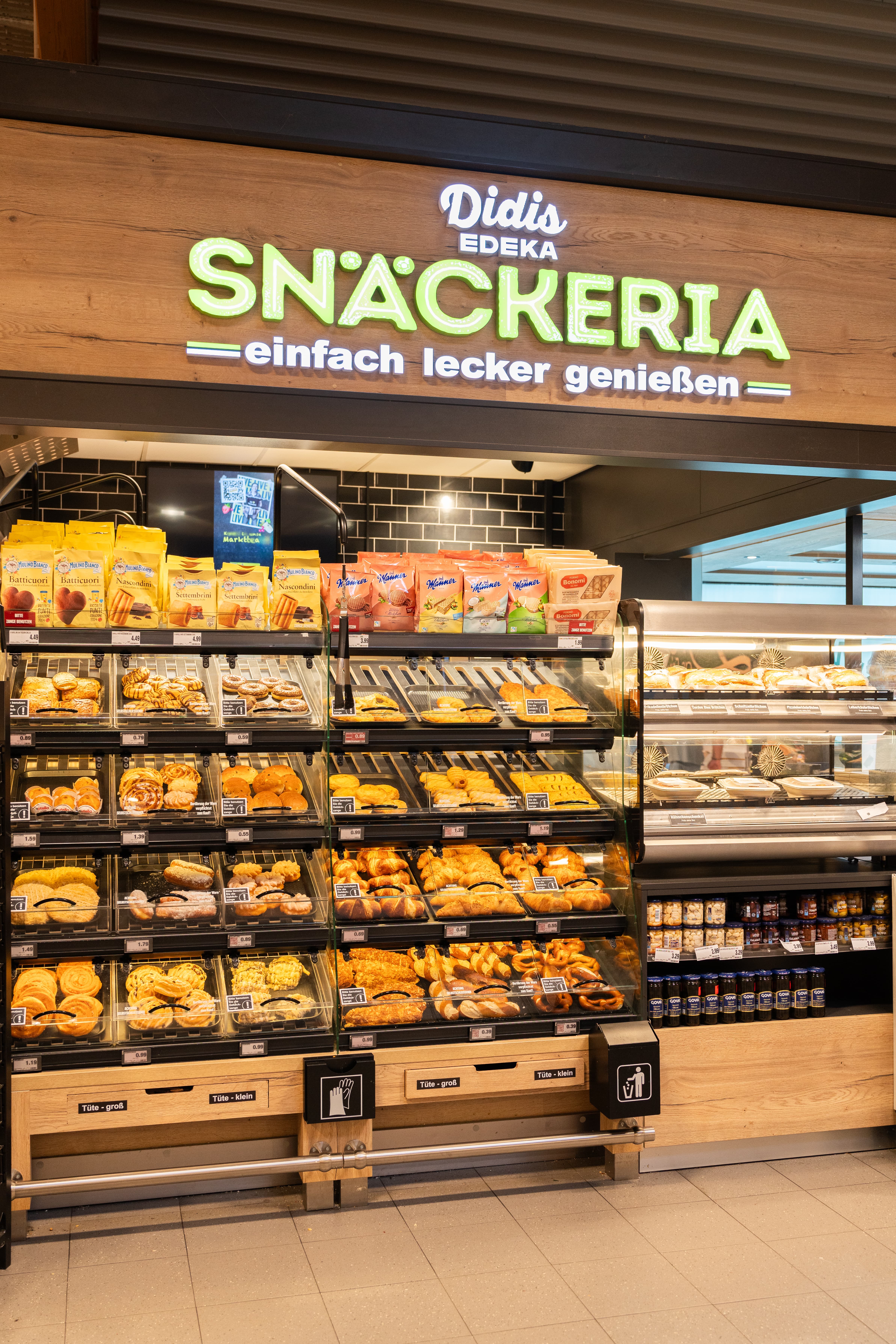 Backshop eines Edeka-Marktes. Über den Backshop steht ein Schriftzug mit der Aufschrift "Didis Edeka - Snäckeria - einfach lecker genießen".