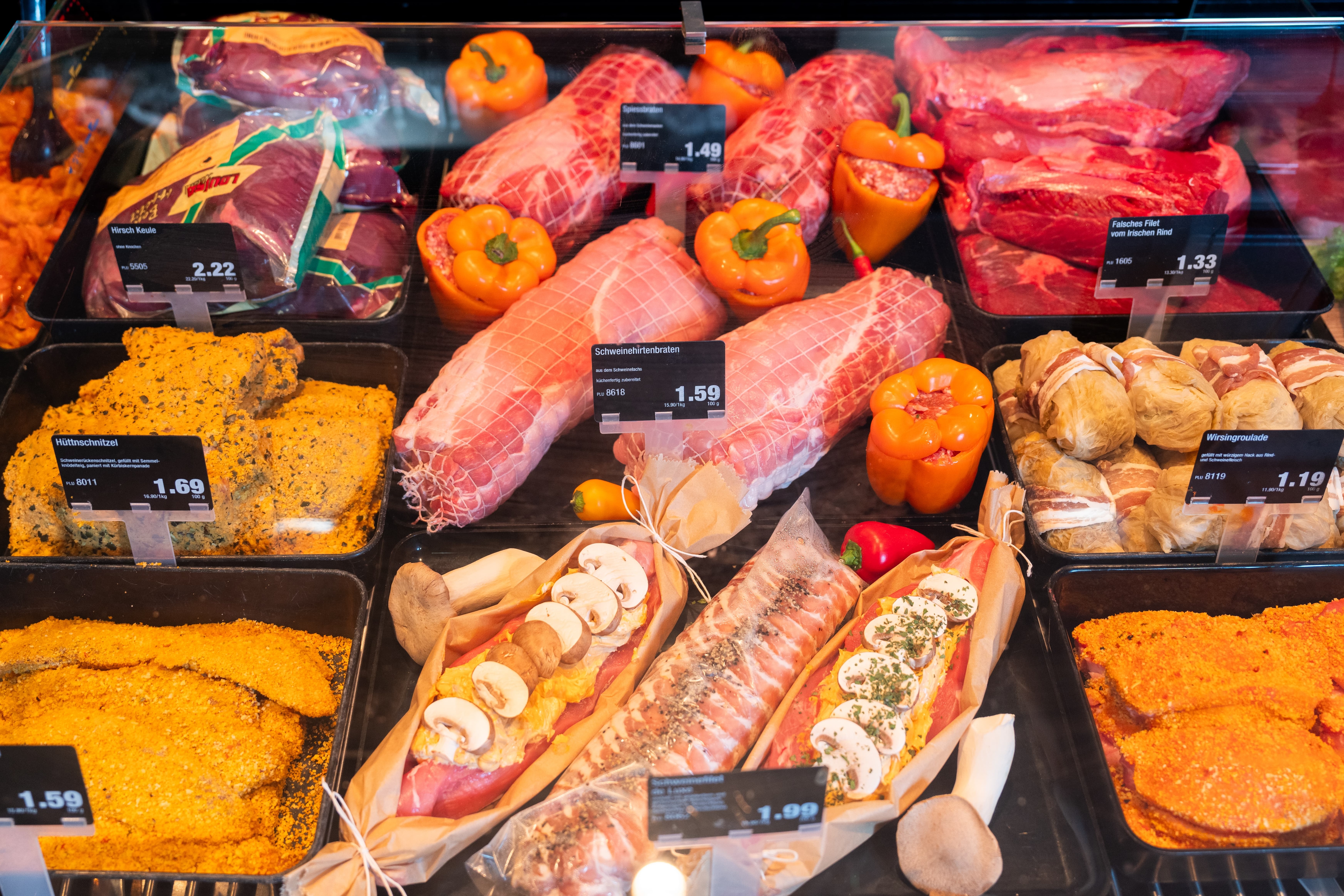 Verschiedene Fleischwaren mit Preisschildern in einer Auslage der Fleischtheke.