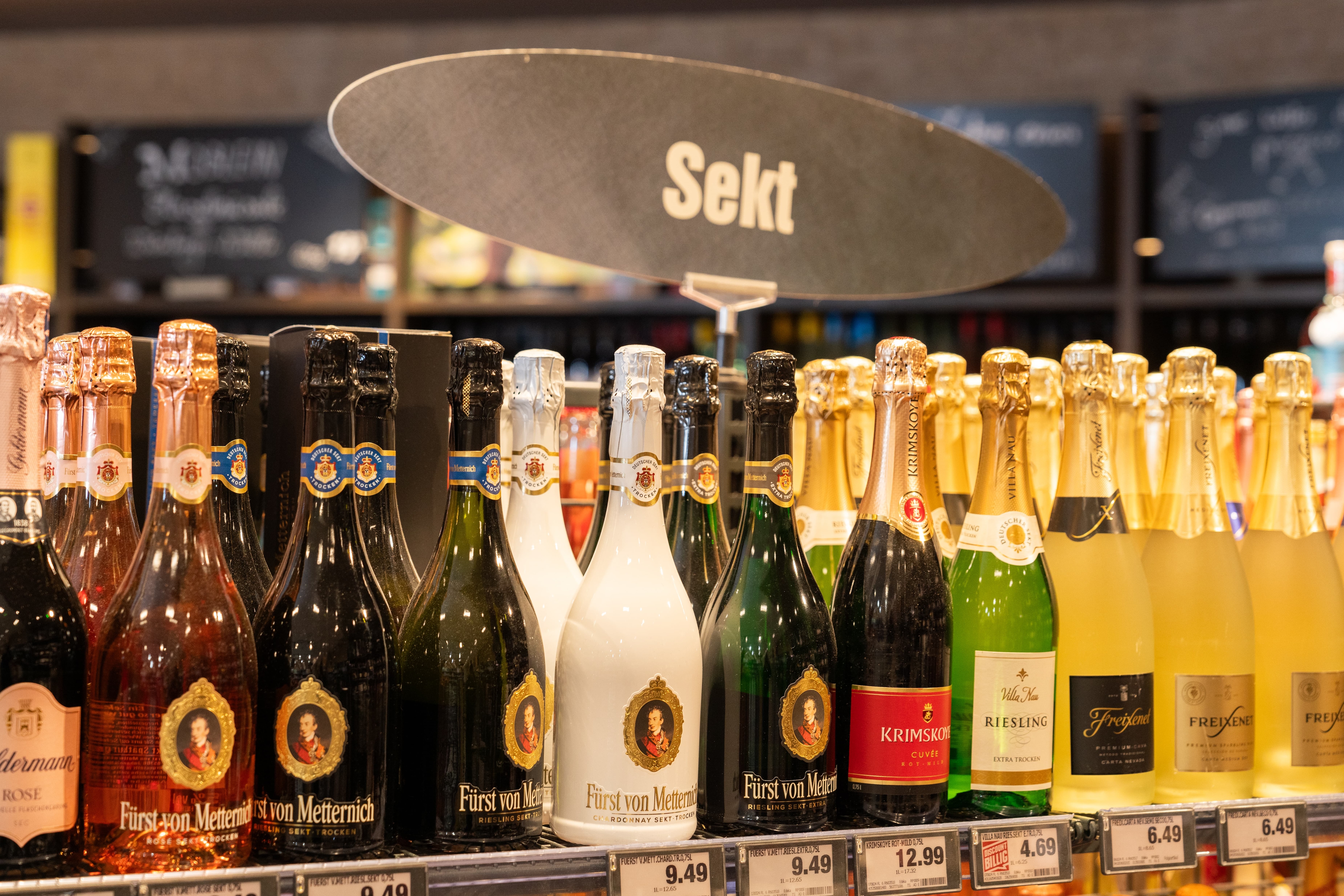 Nahaufnahme eines Regals mit Sektflaschen.