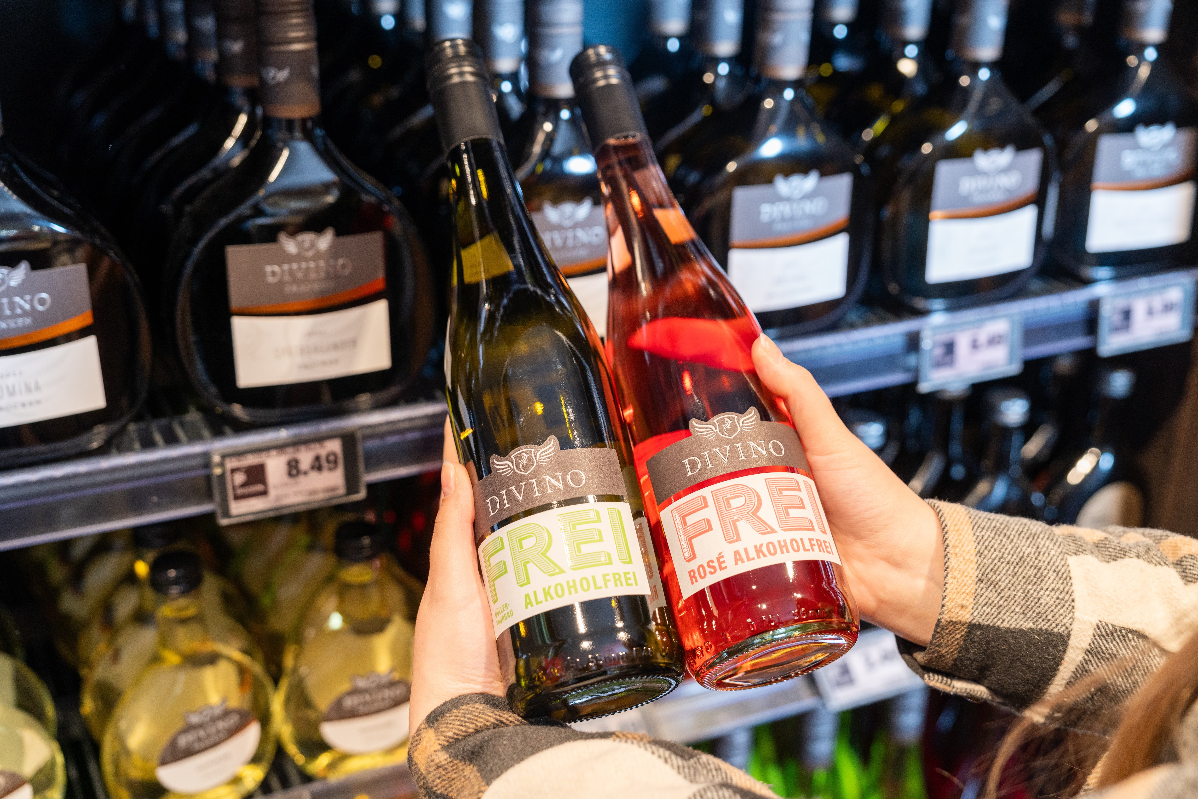 Zwei Hände halten jeweils eine Flasche alkoholfreien Wein.