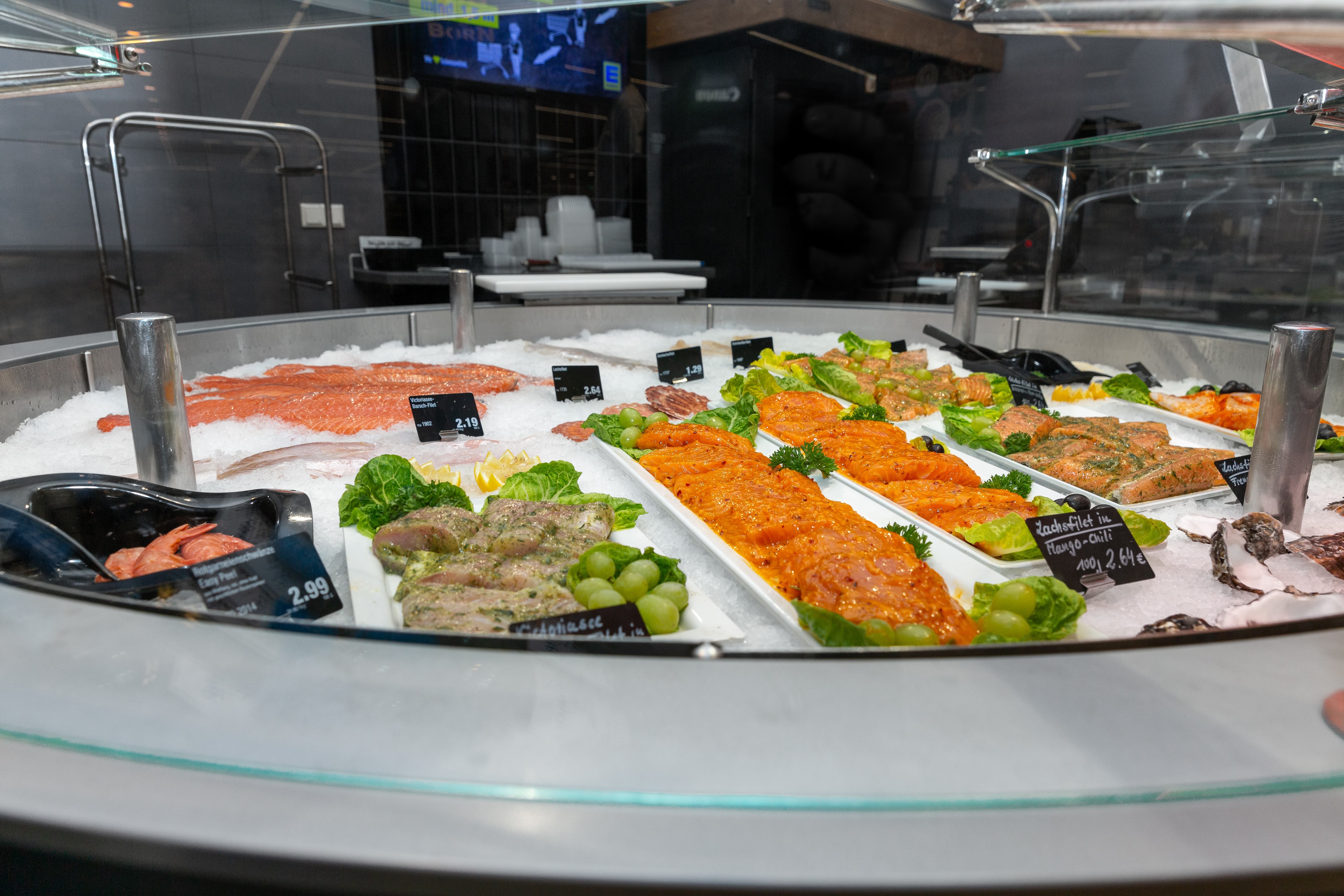 Verschiedene Fischfilets mit Preisschildern in einer Auslage.