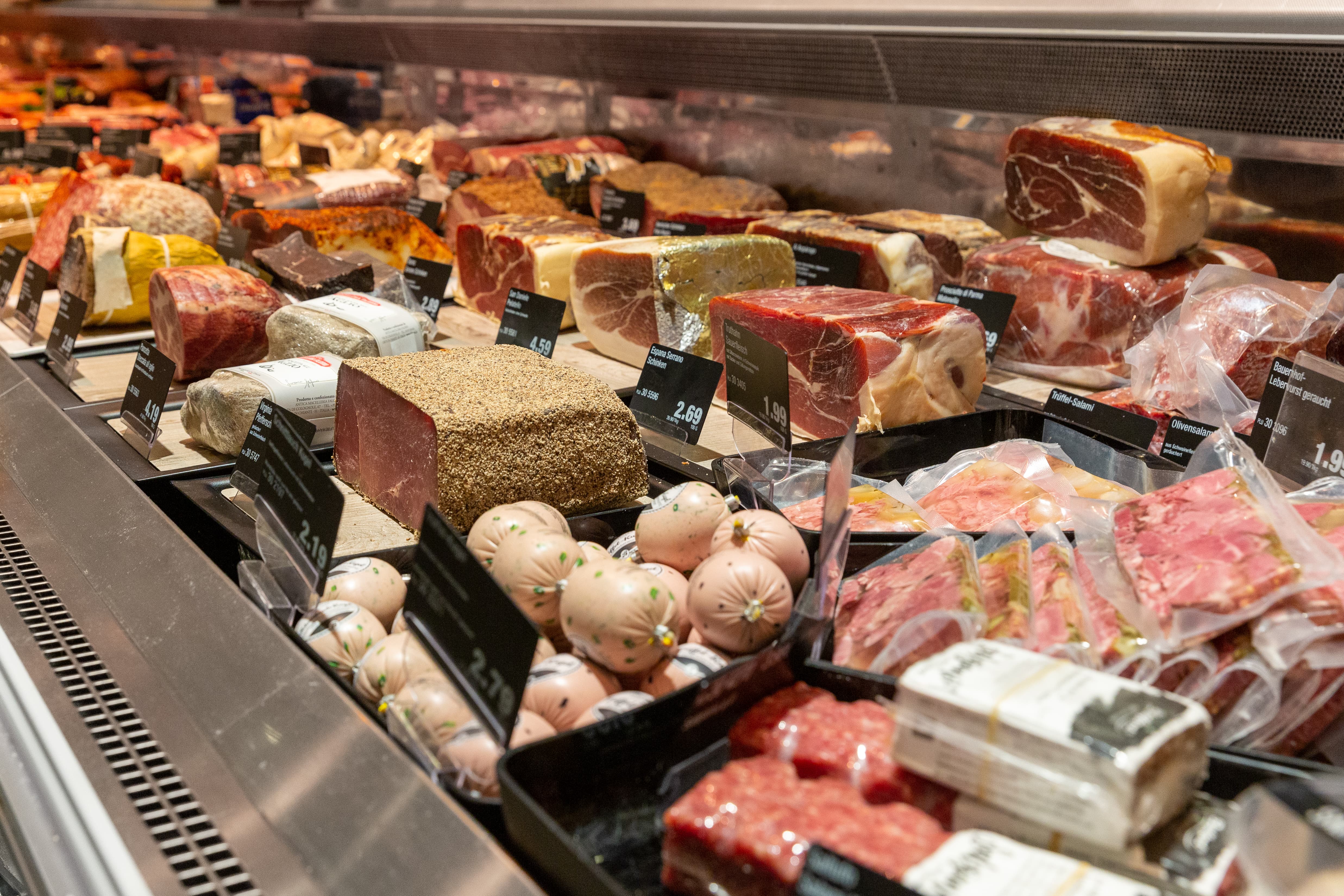 Nahaufnahme von einem Bereich der Fleischtheke in dem verschiedene Fleischprodukte ausliegen.