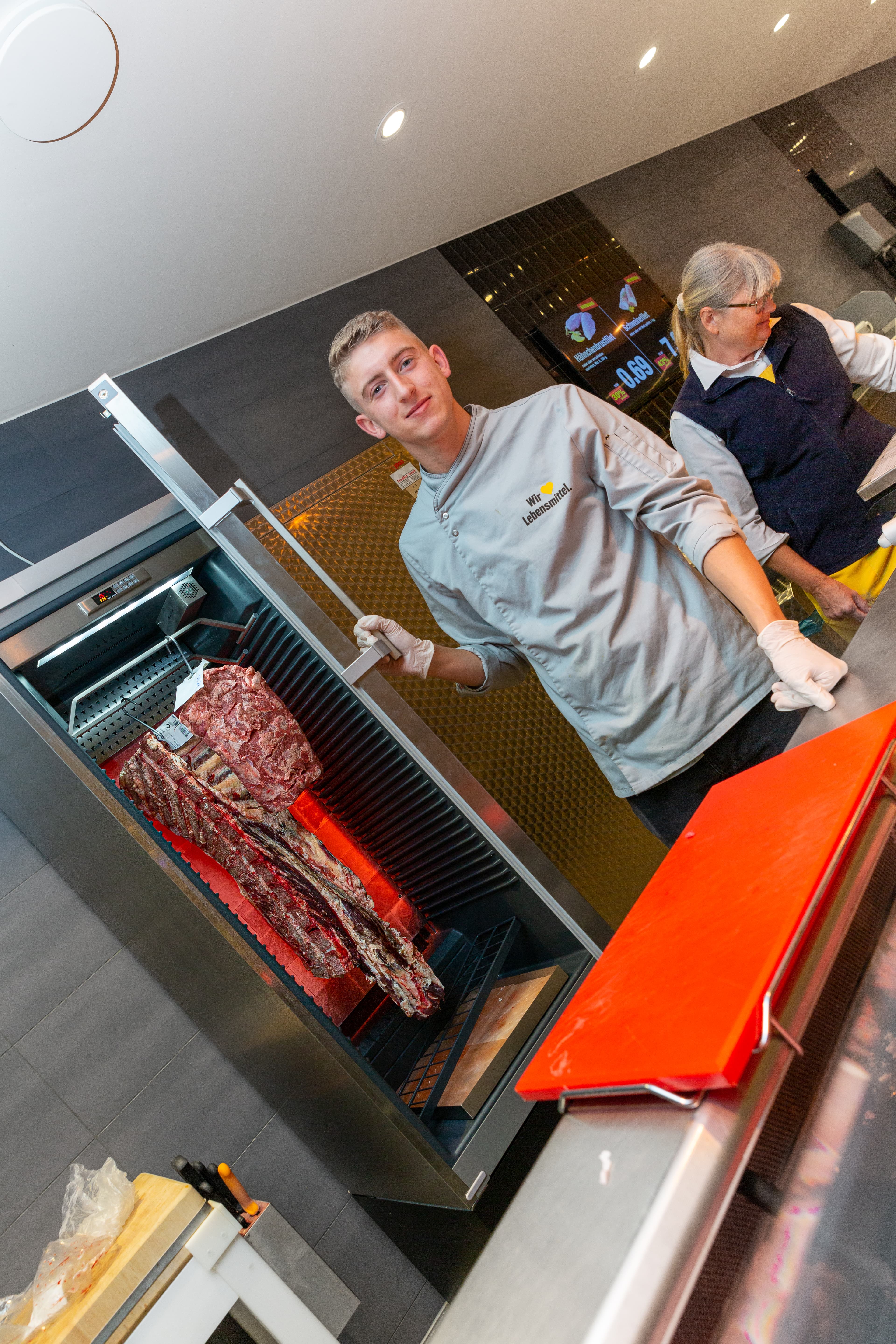 Ein Mitarbeiter öffnet den Schrank in dem das DryAged-Fleisch hängt.