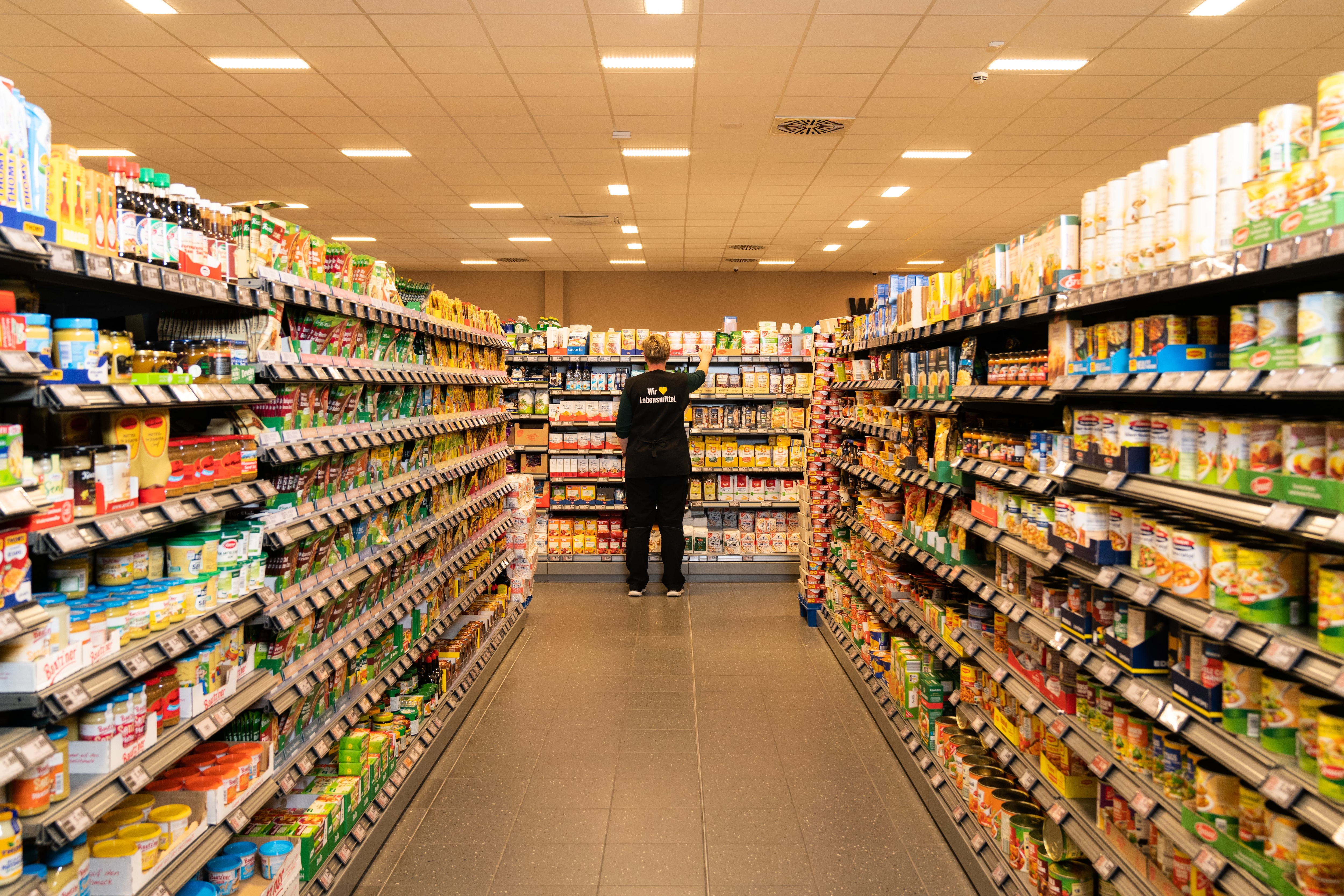 Der Gang eines Supermarktes. Links sind Saucen und Convenienceprodukte, auf der rechten Seite Konserven.