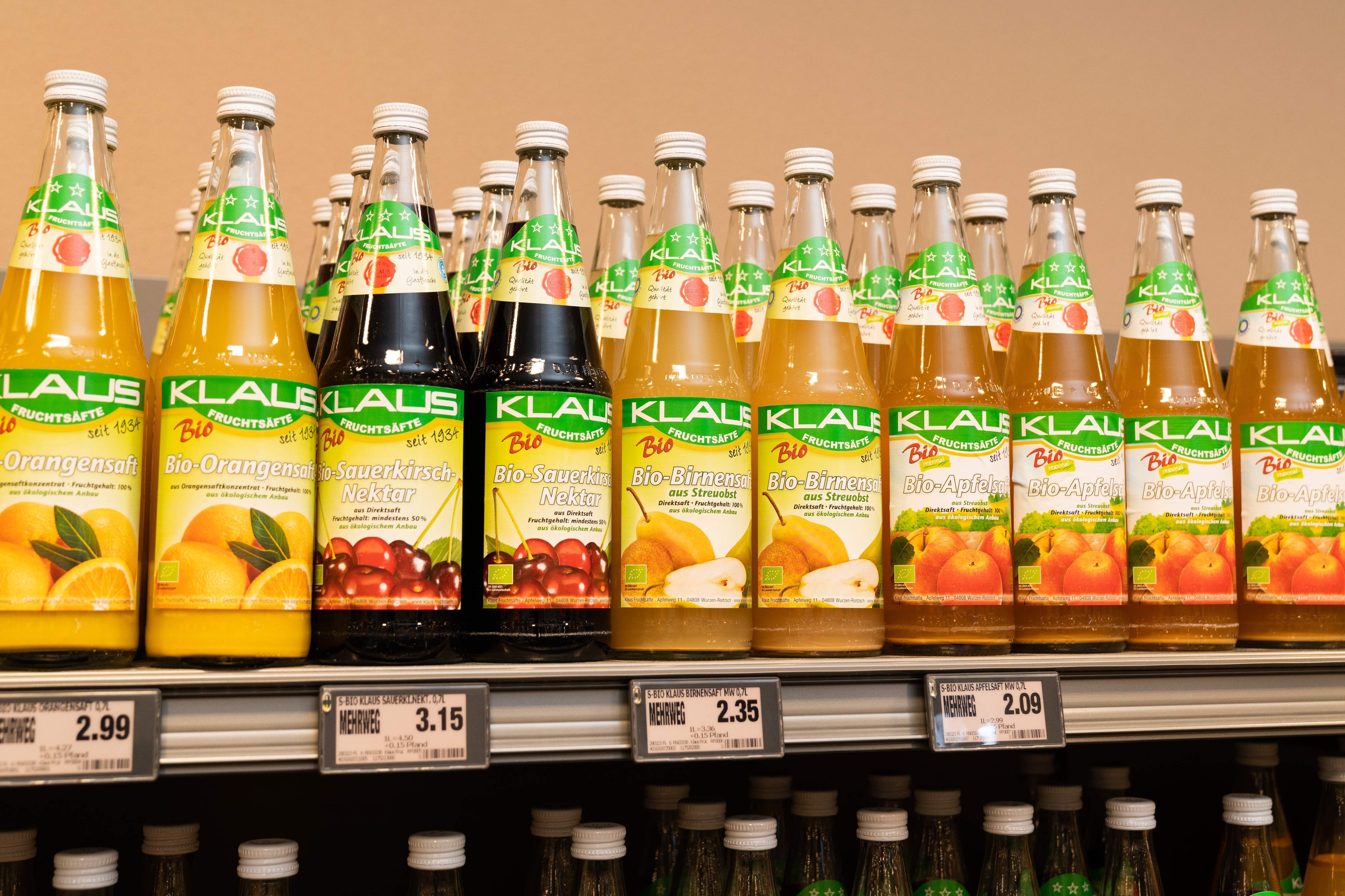 Verschiedene Fruchtsäfte der Marke Klaus: Orange, Bio-Sauerkirsch-Birne, Apfel in Glasflaschen.