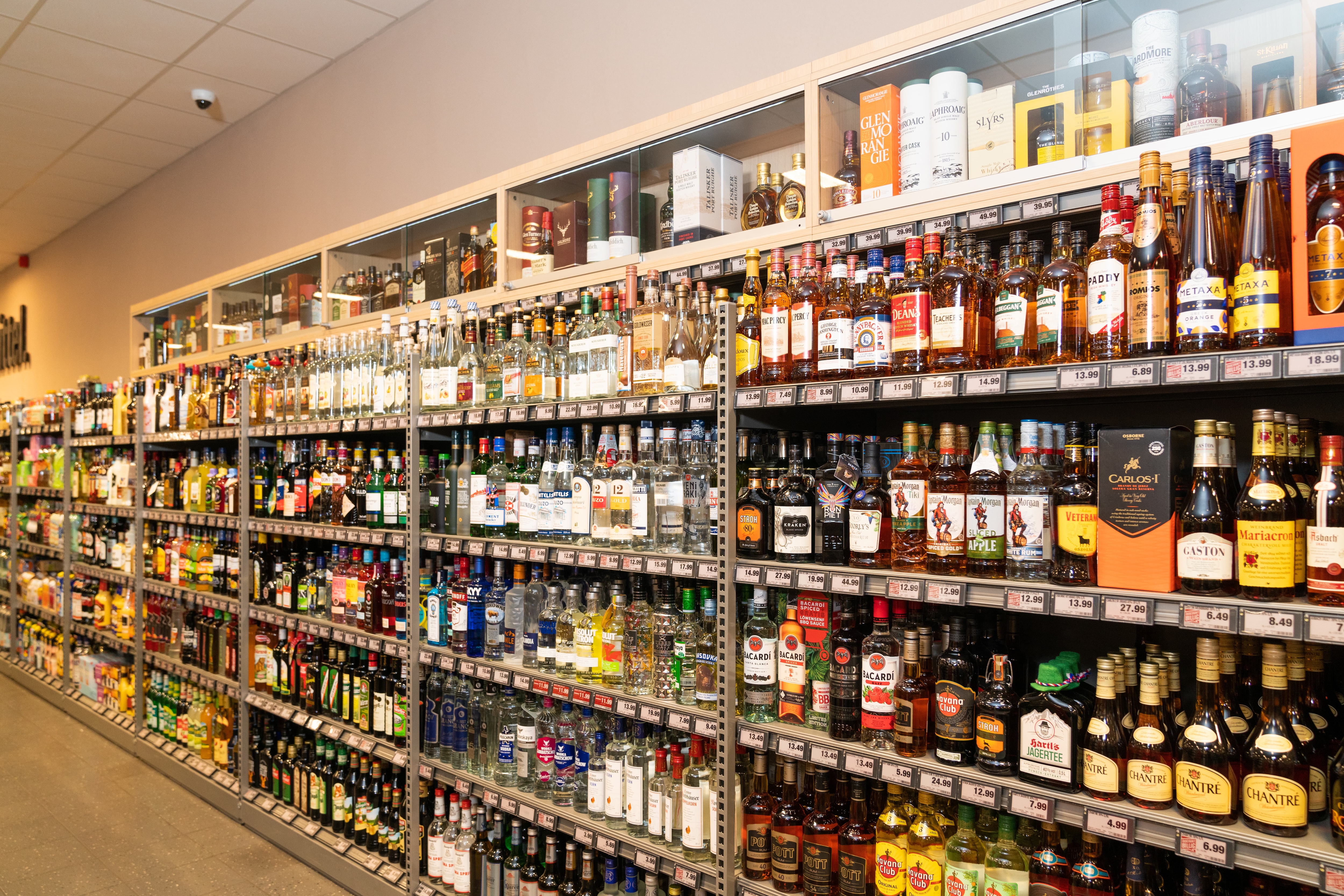 Langes Spirituosenregal mit bunten Flaschen.