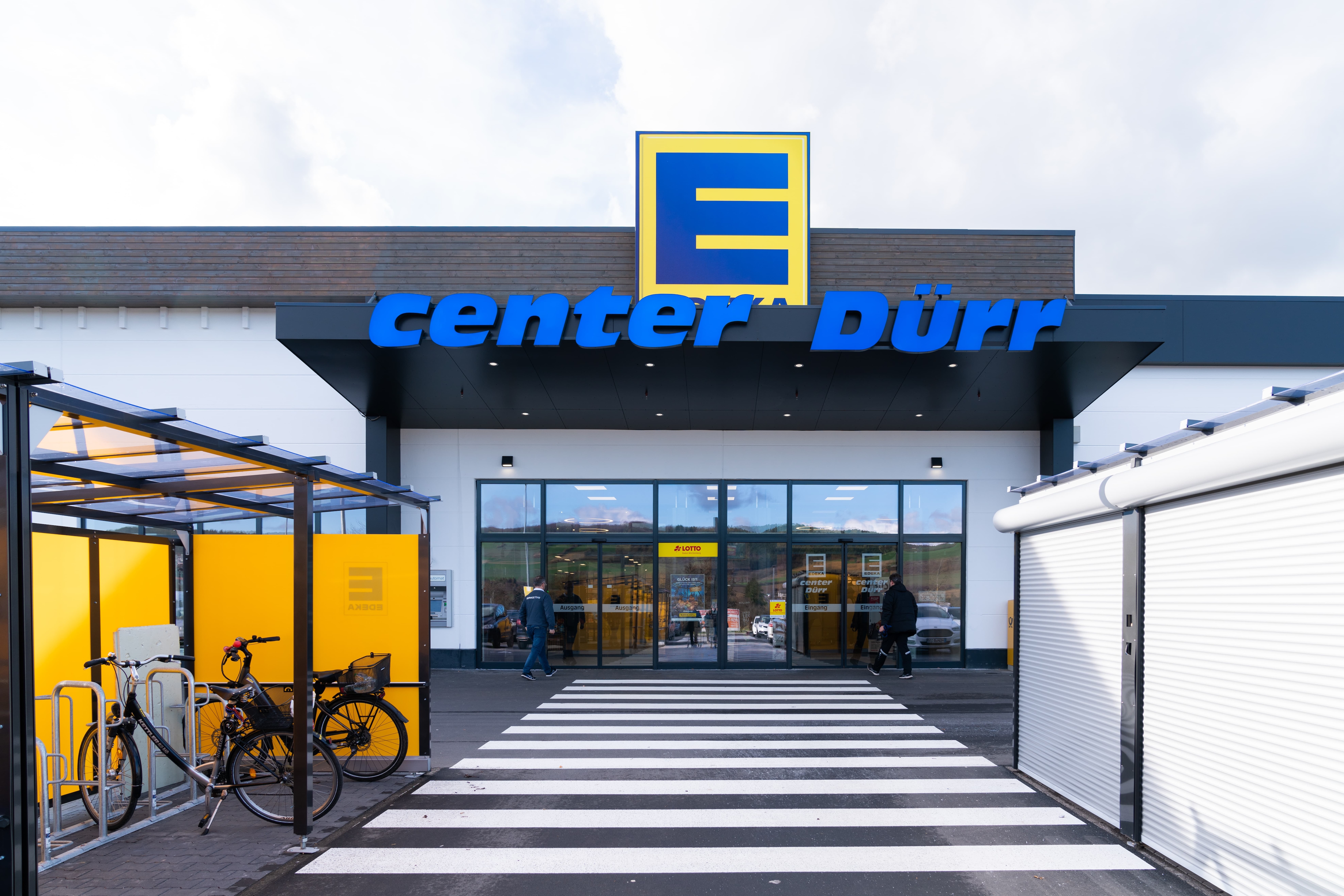 Eingangsbereich des EDEKA center Dürr mit überdachten Fahrradständern.