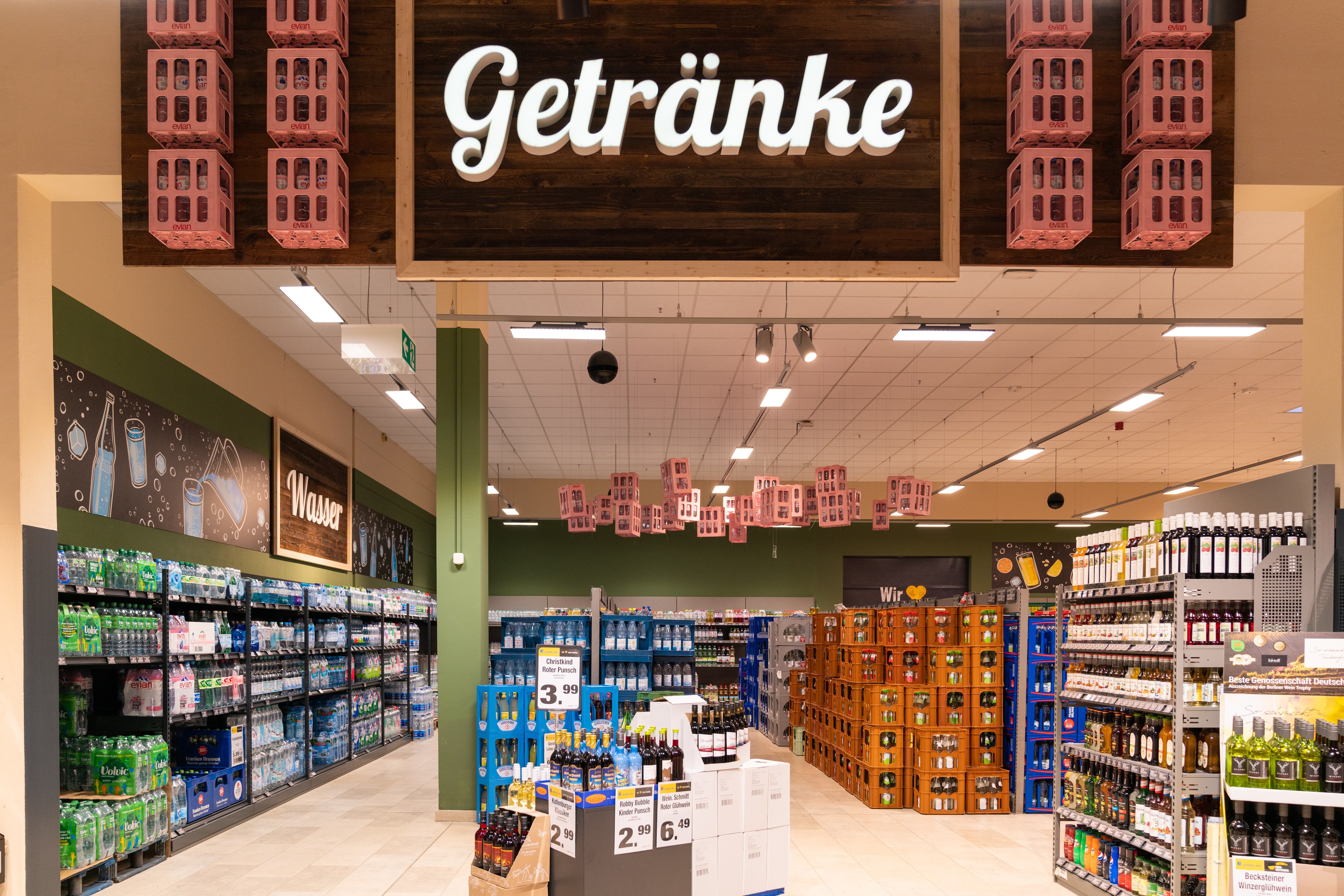 Getränkemarkt mit Wasserregalen sowie freistehenden Kisten.