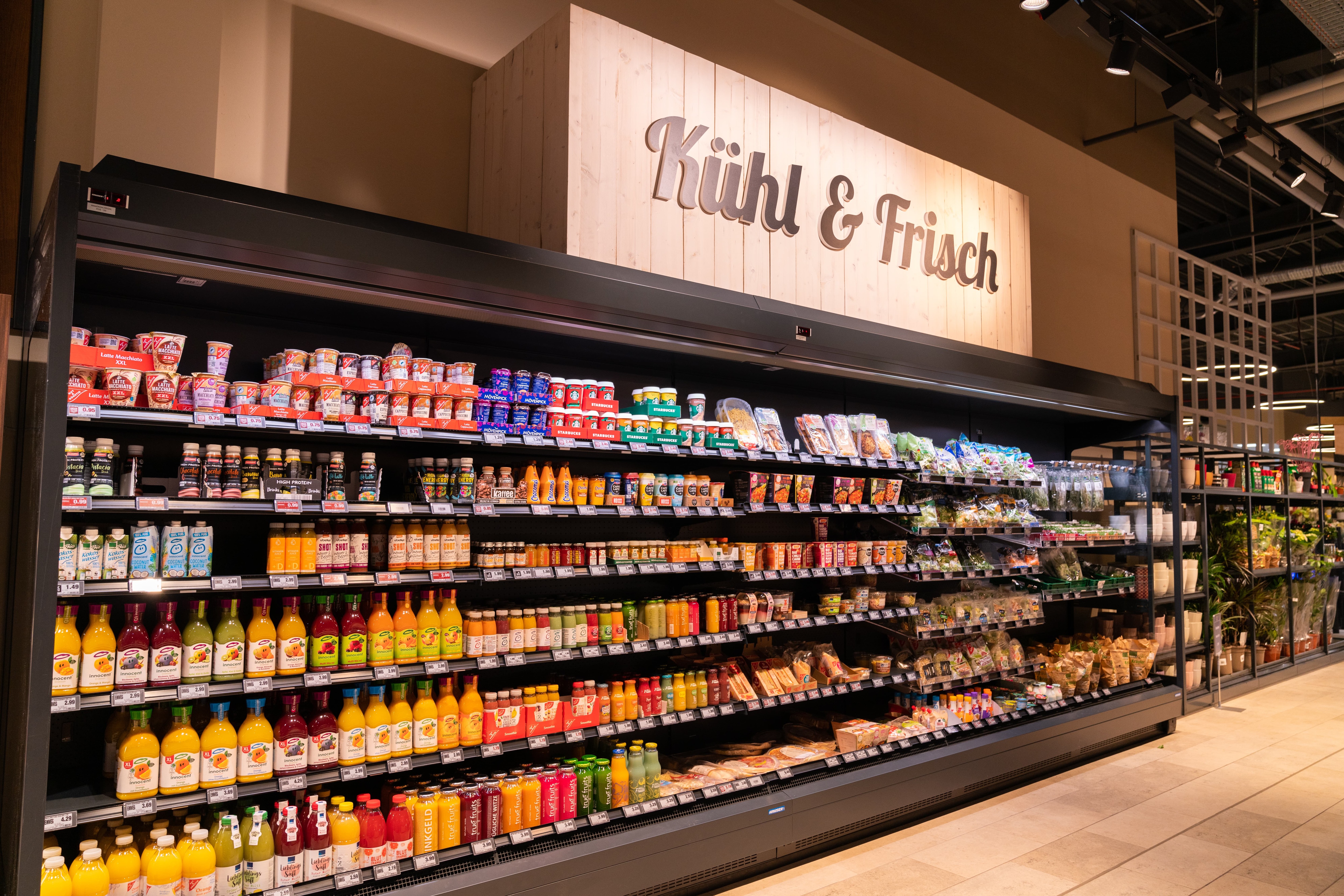 Kühlregal mit Getränken und Convenience-Food. Darüber steht kühl und frisch.