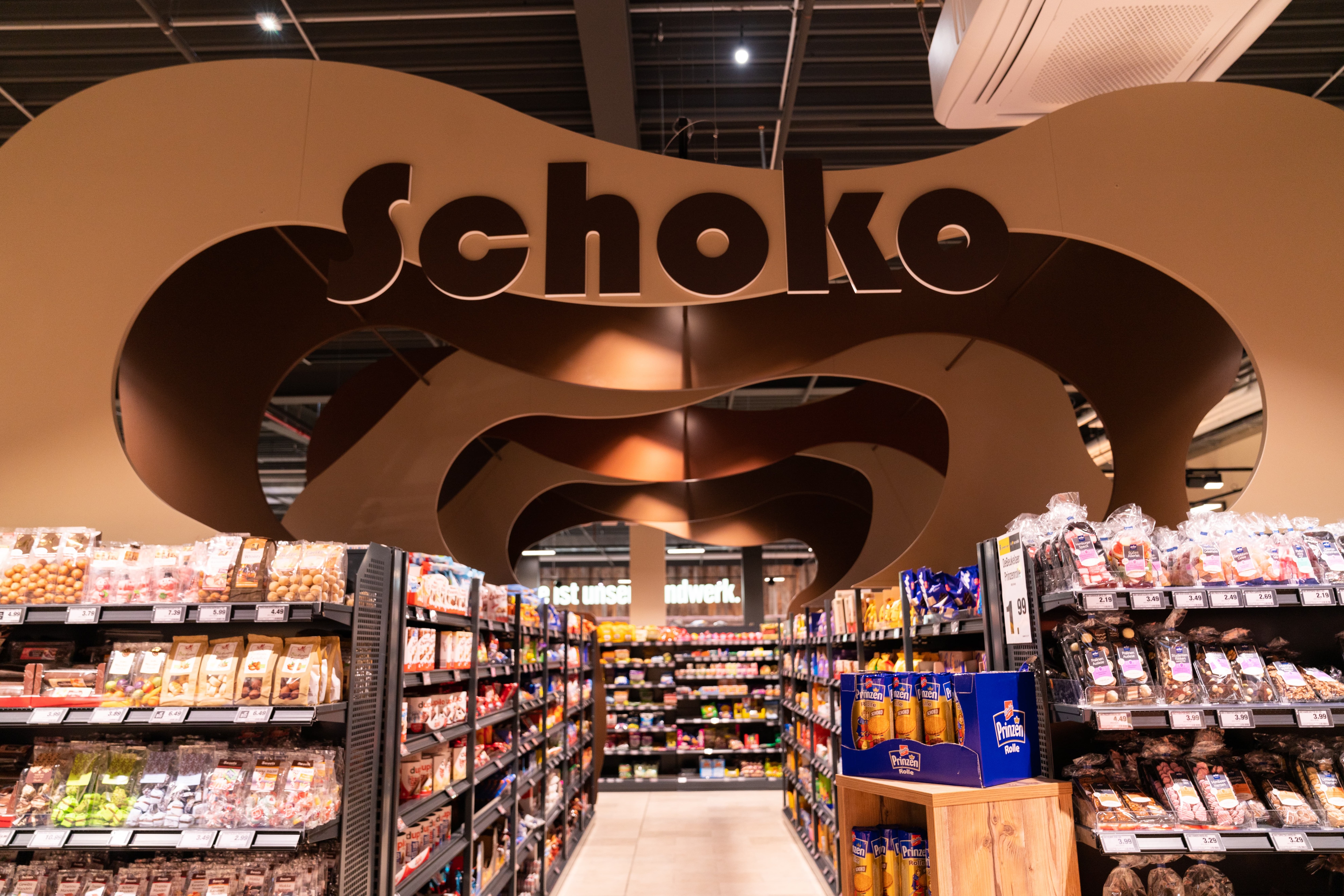 Über einem Gang steht in großen, braunen Buchstaben: Schoko.