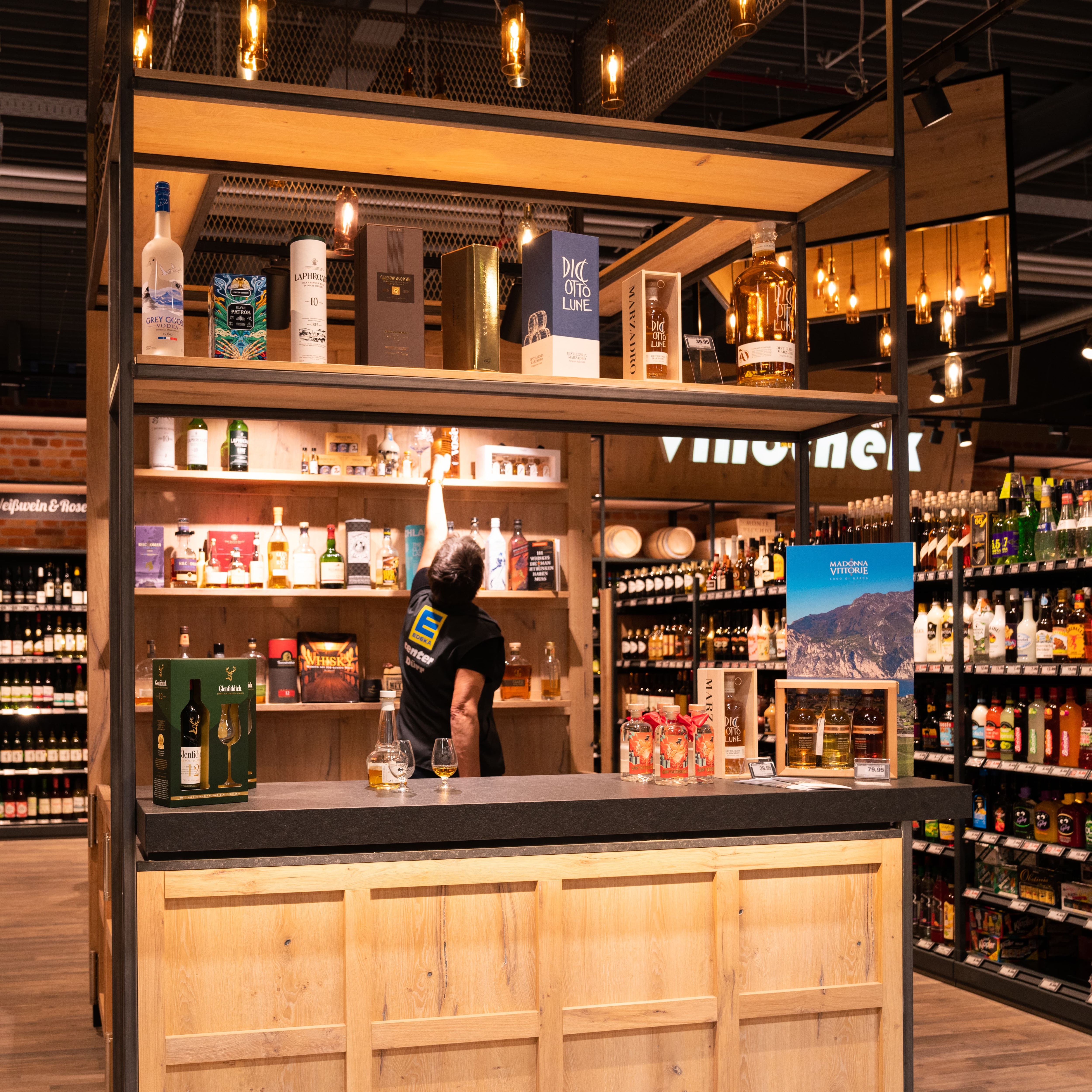Ein Holzstand mit Tresen, an dem verschiedene Getränke zum Probieren angeboten werden.