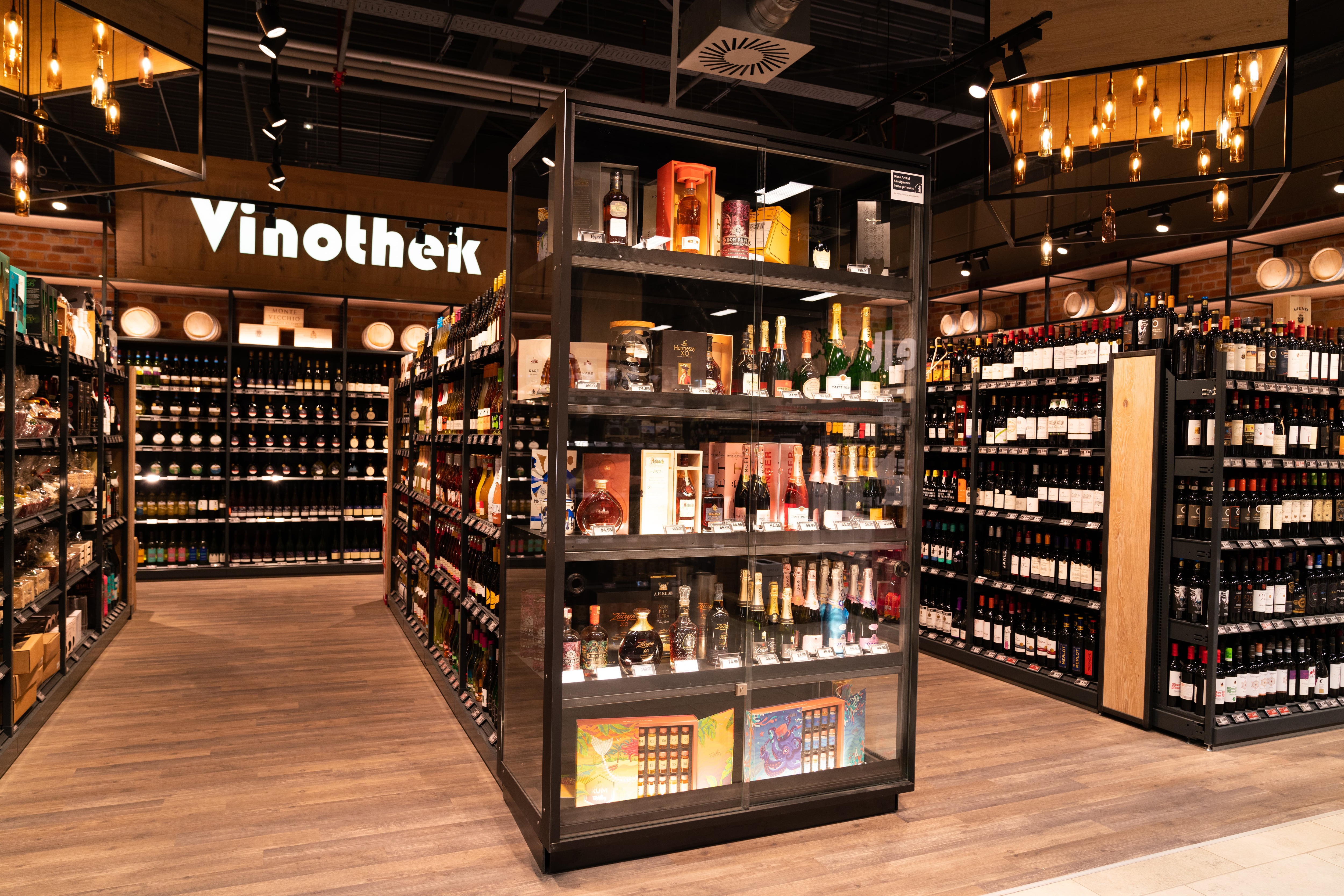In der warm beleuchteten Weinabteilung steht Vinothek an der Wand.