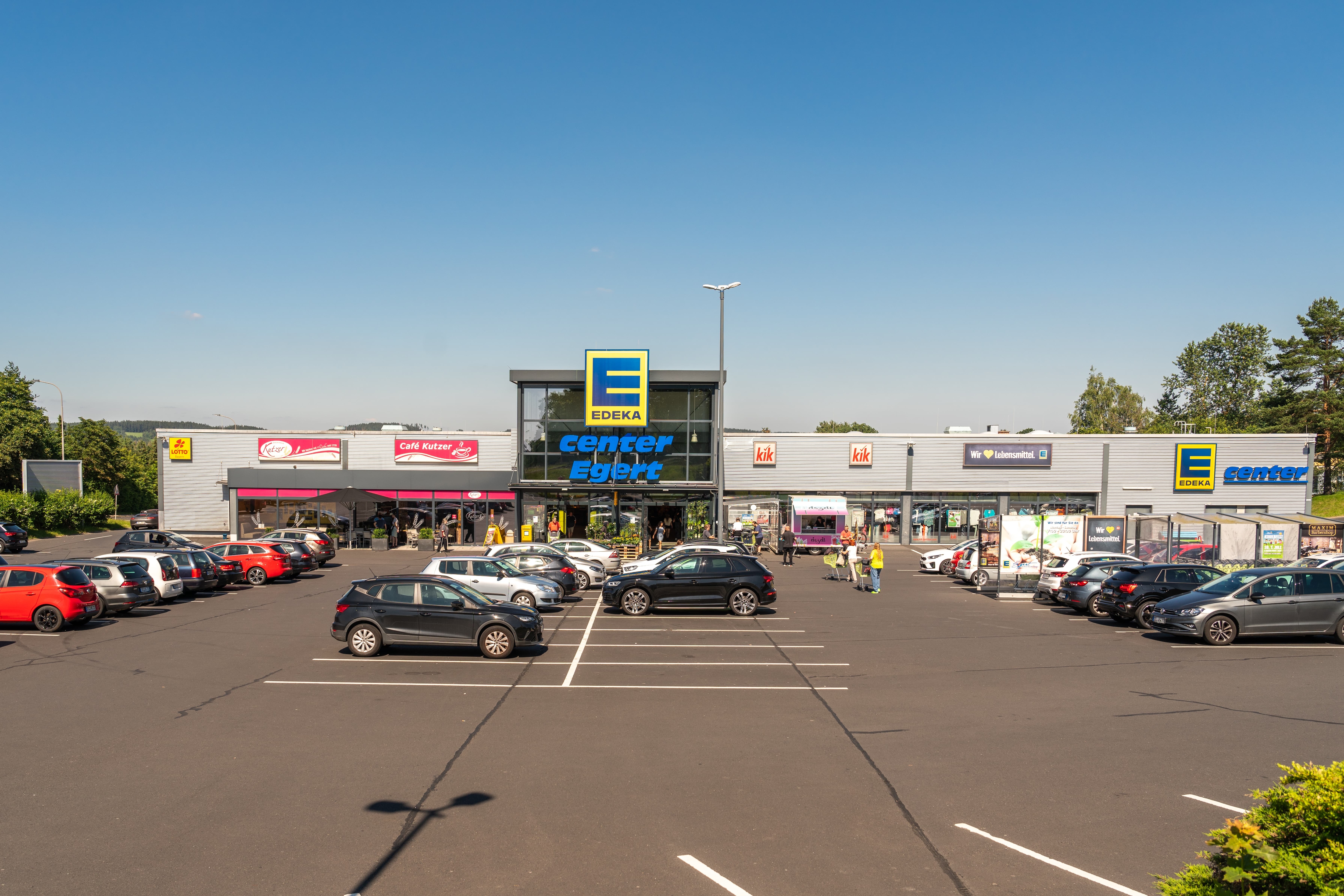 Die Außenansicht eines EDEKA-Centers mit dem davor befindlichen Parkplatz.
