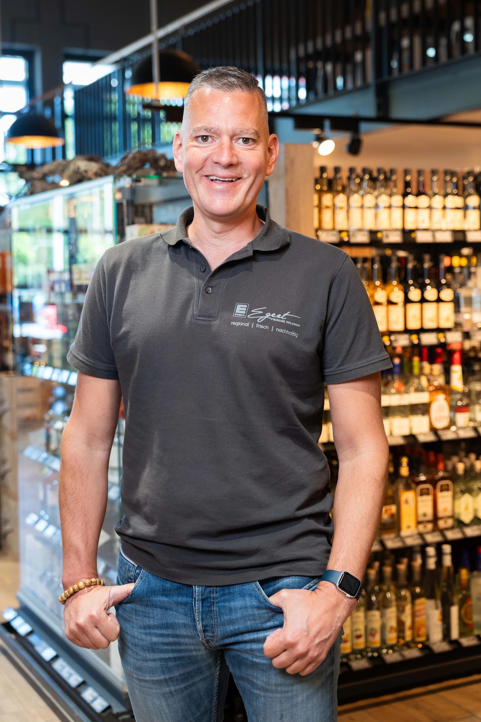 Der lächelnde Inhaber eines EDEKA-Marktes.