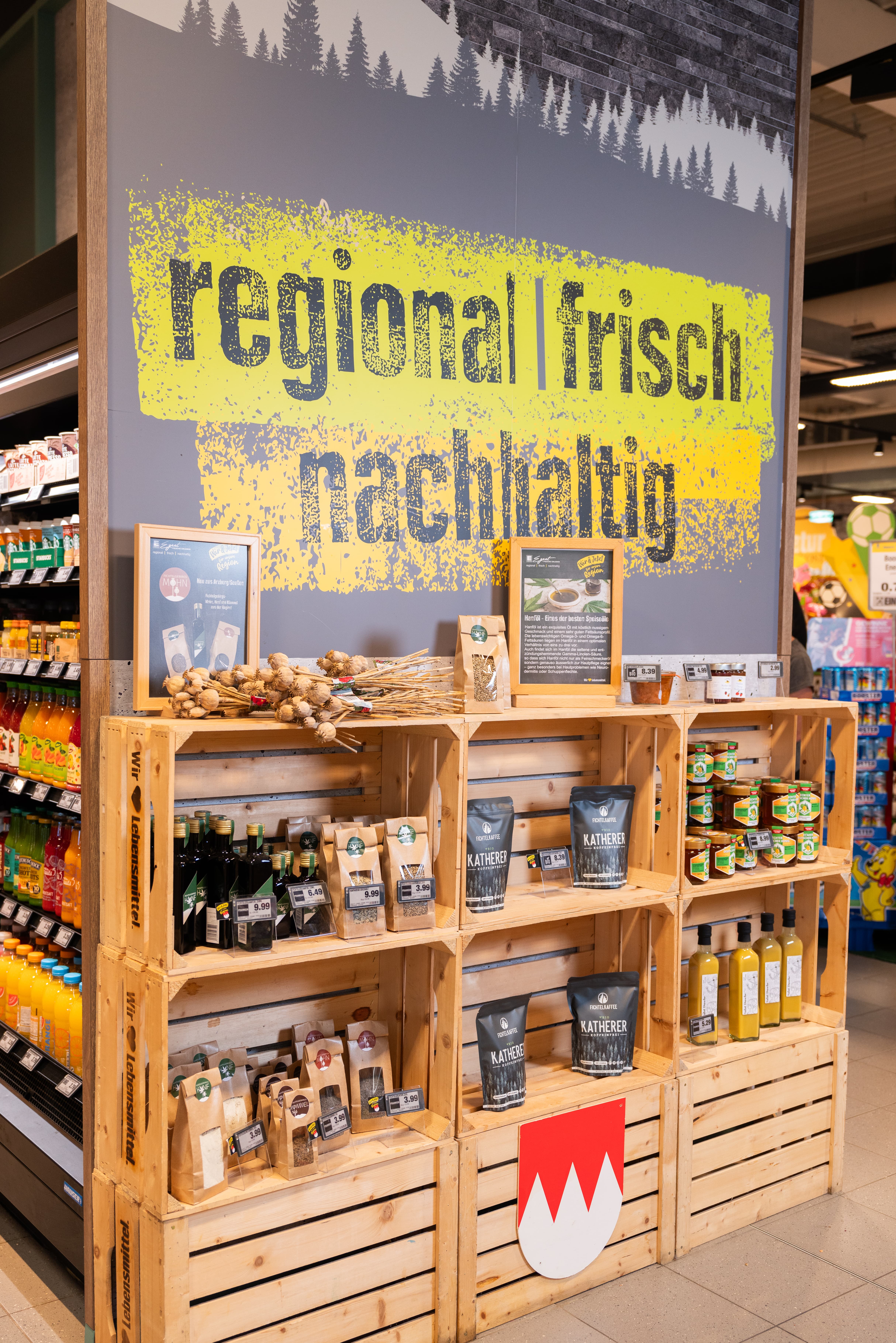 Ein Regal aus Holzkisten in dem verschiedene regionale Produkte ausliegen.