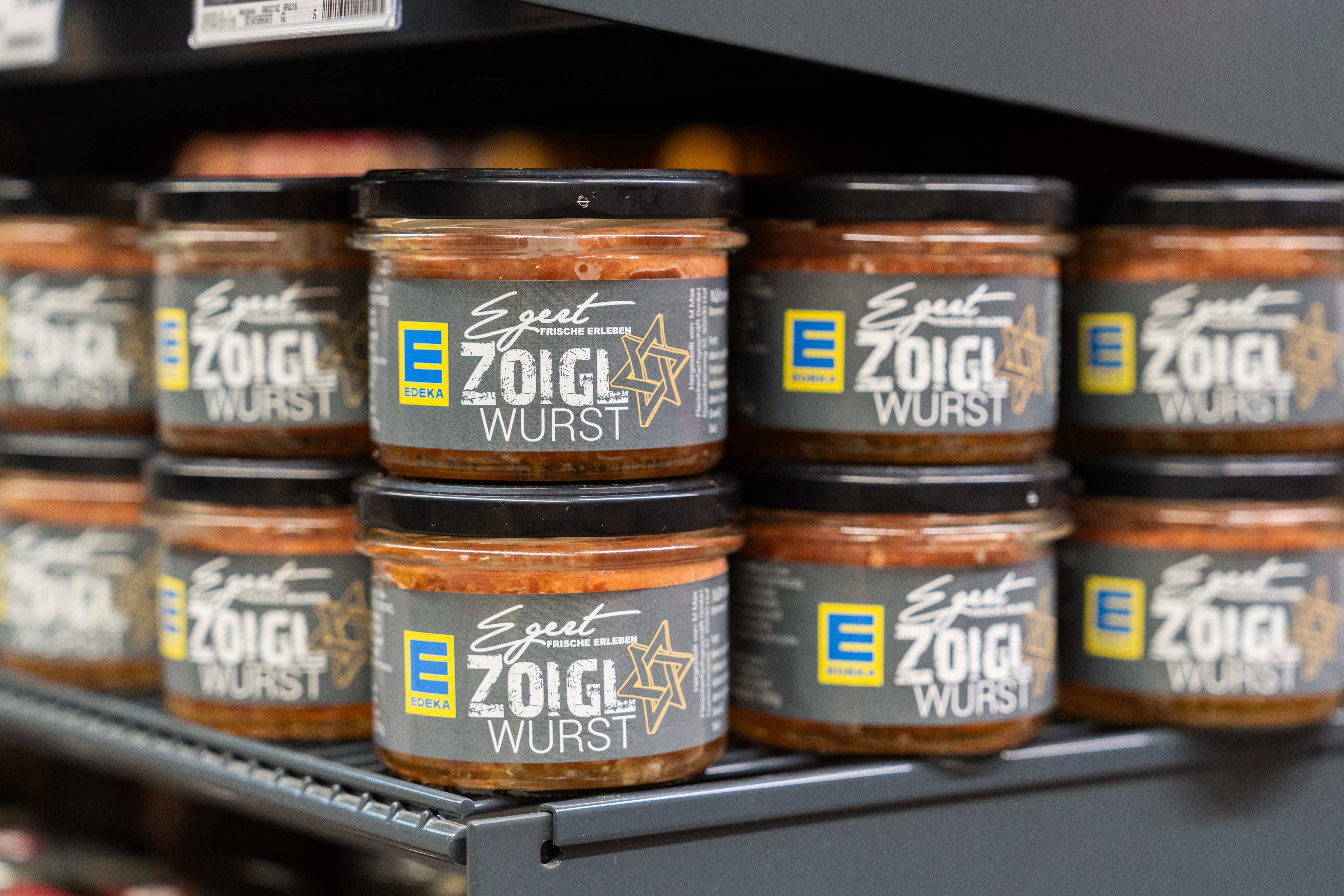 Nahaufnahme mehrerer Gläser "Zoigl Wurst" in einem Regal.