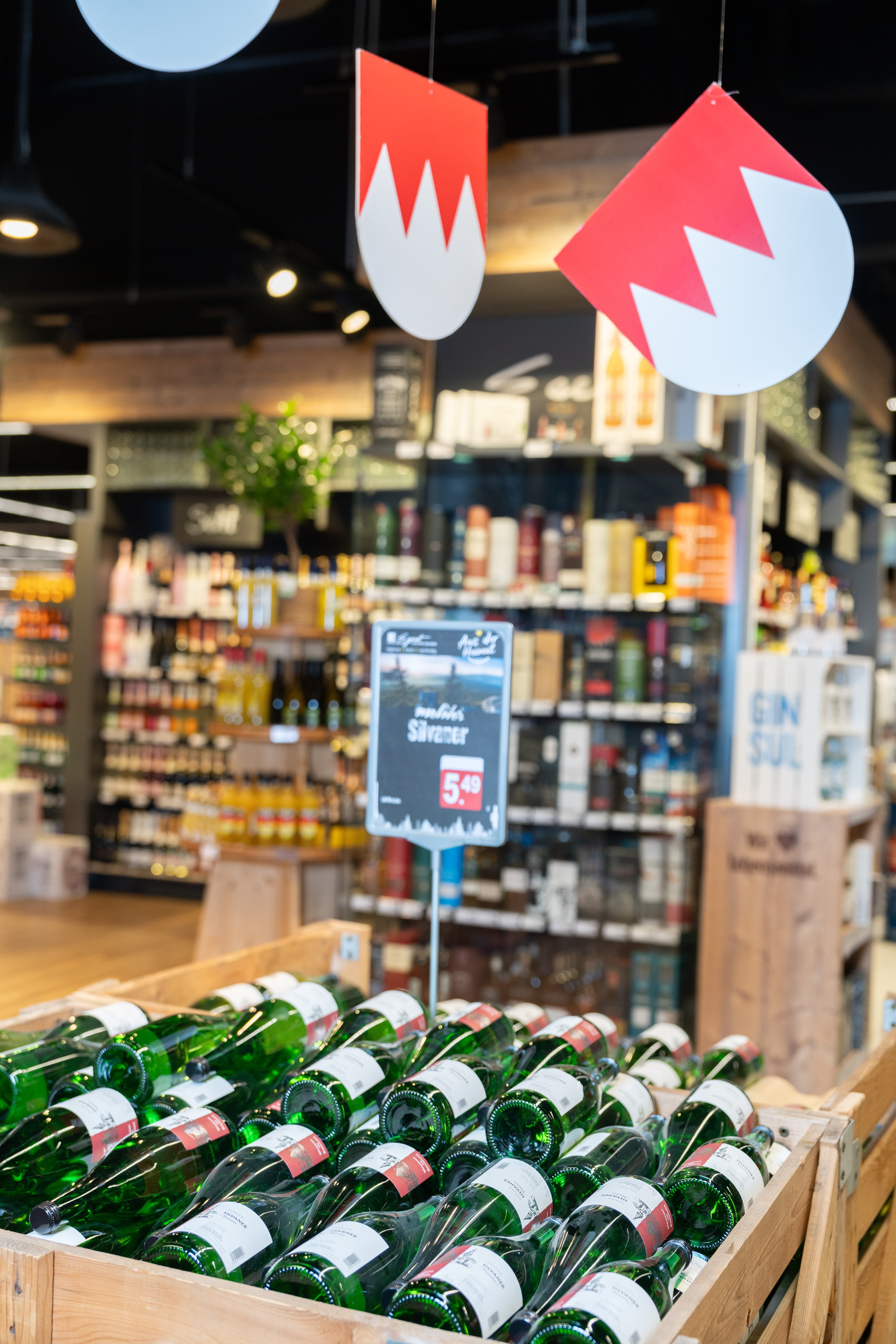 Eine große Holzkiste mit Weinflaschen in einem EDEKA-Markt.