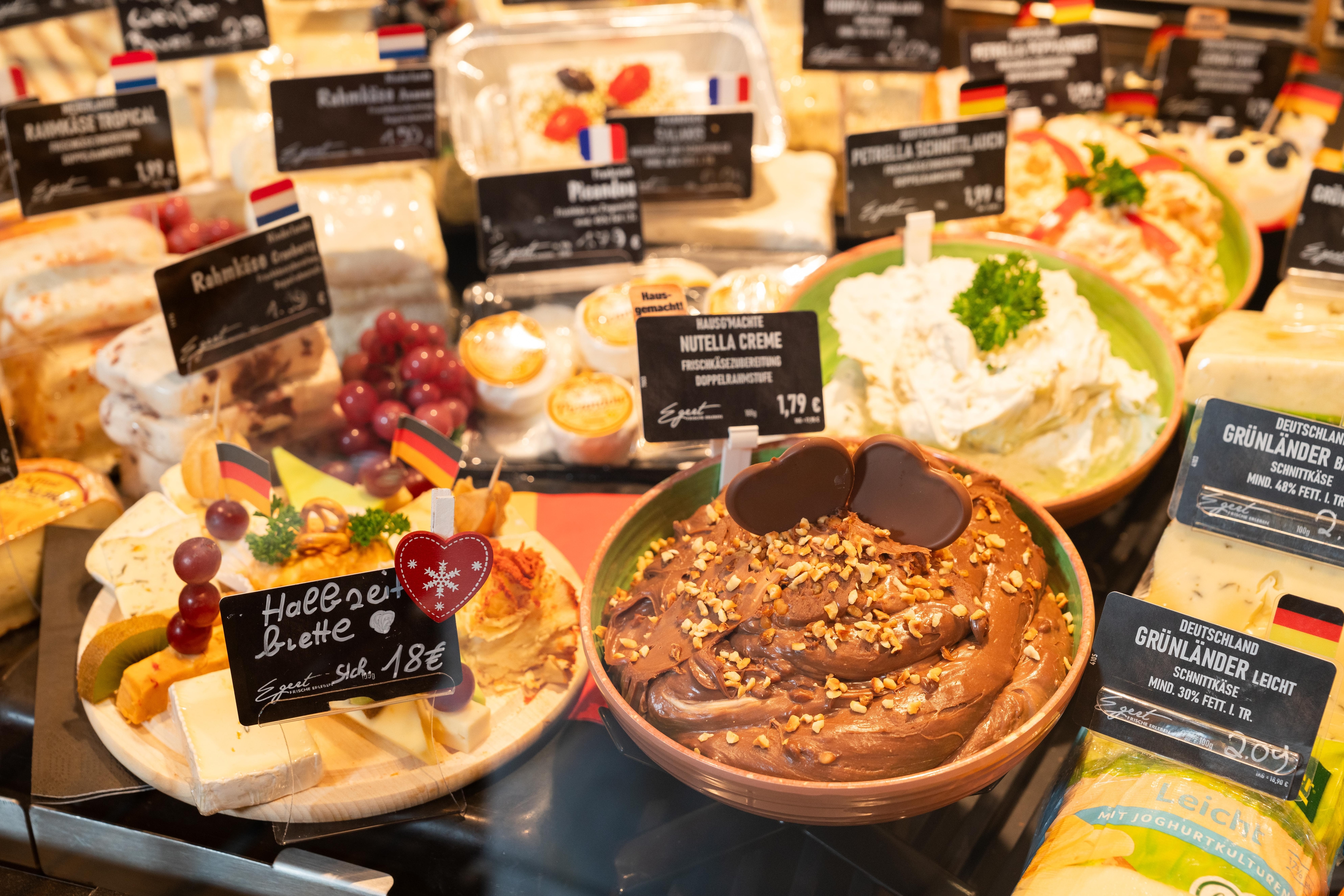 Verschieden Käse- und Frischkäsesorten in der Auslage einer Theke.