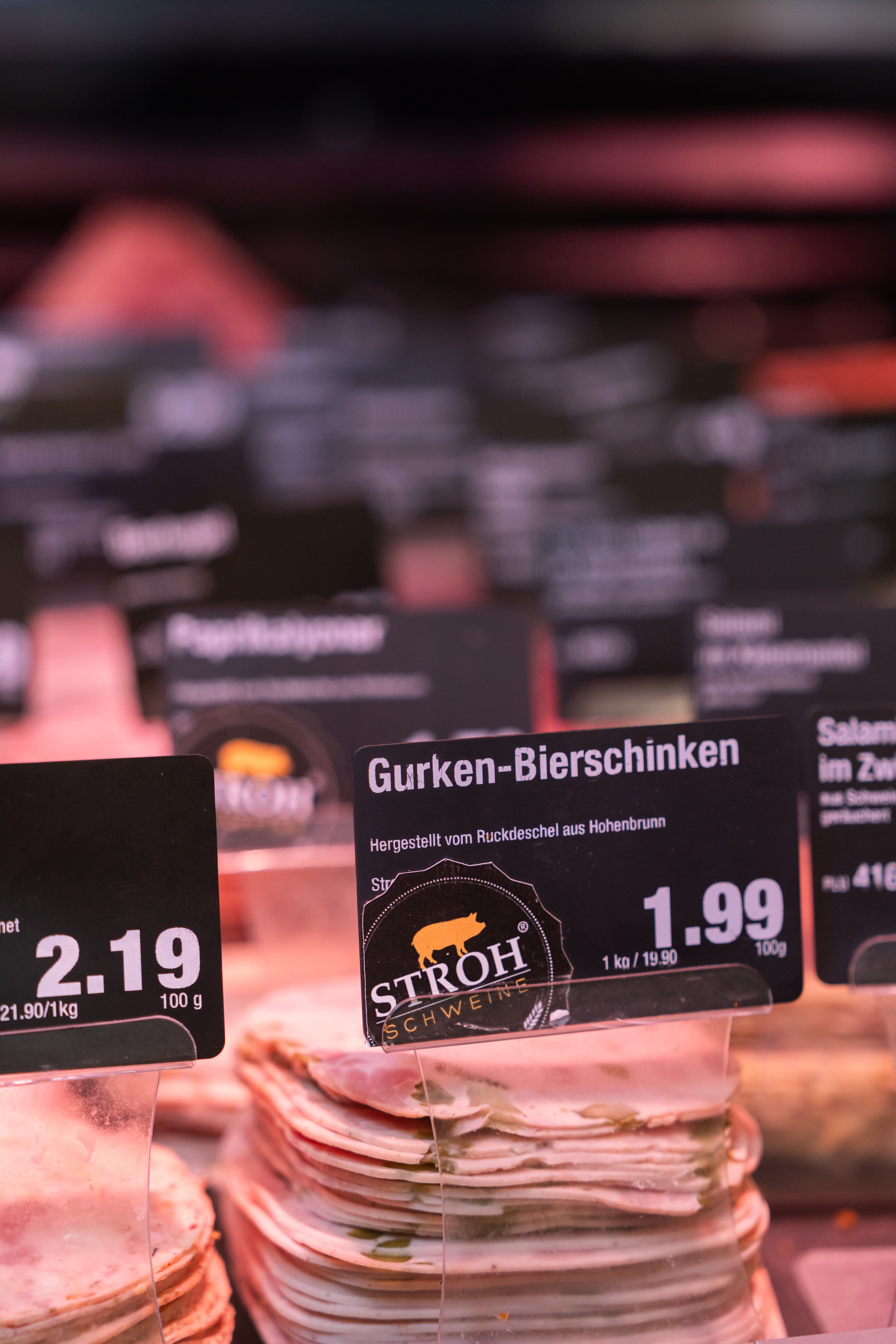 Nahaufnahme eines Gurken-Bierschinkens in der Auslage einer Fleischtheke.