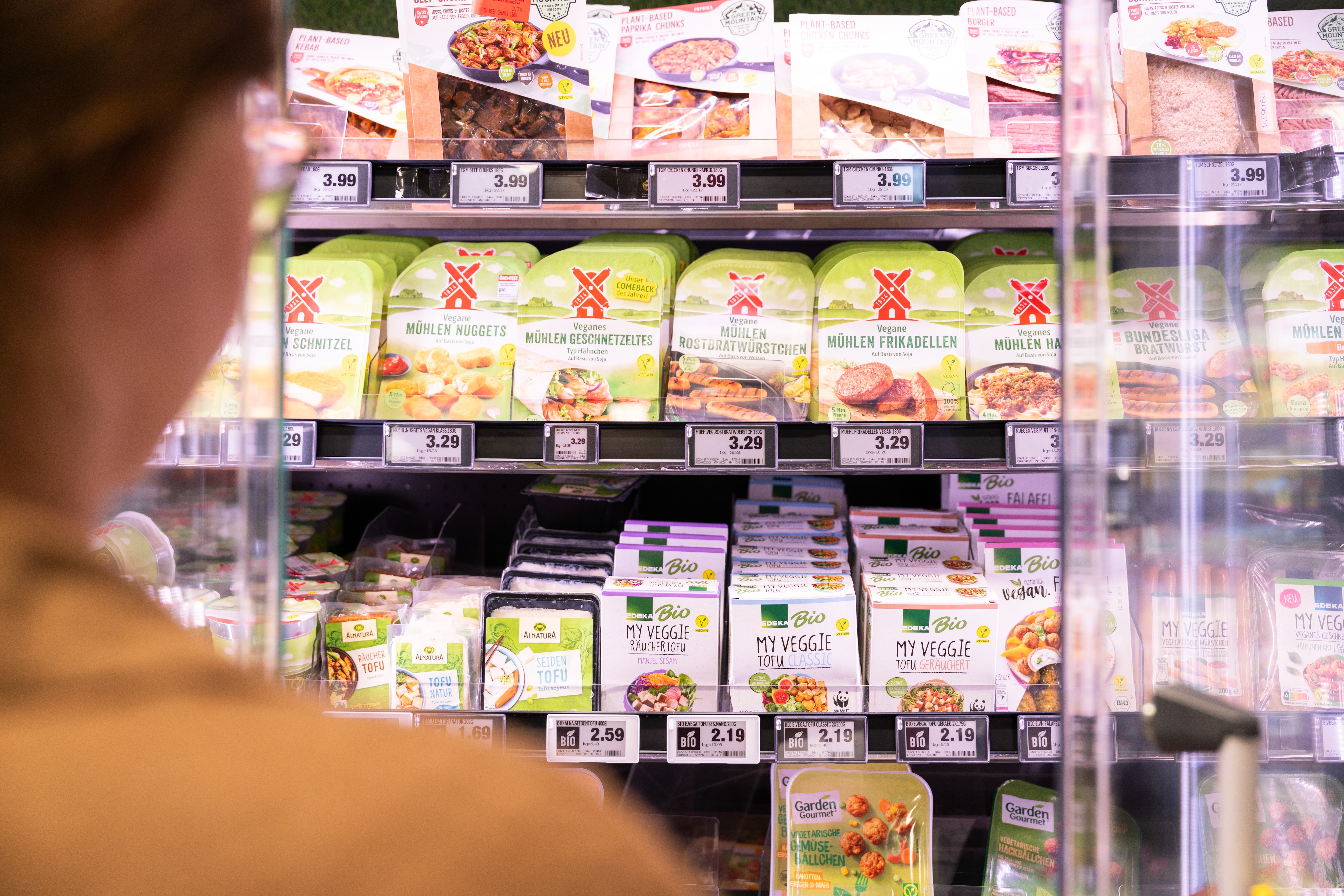 Ein Kühlregal mit verschiedenen veganen und vegetarischen Fleischalternativen.