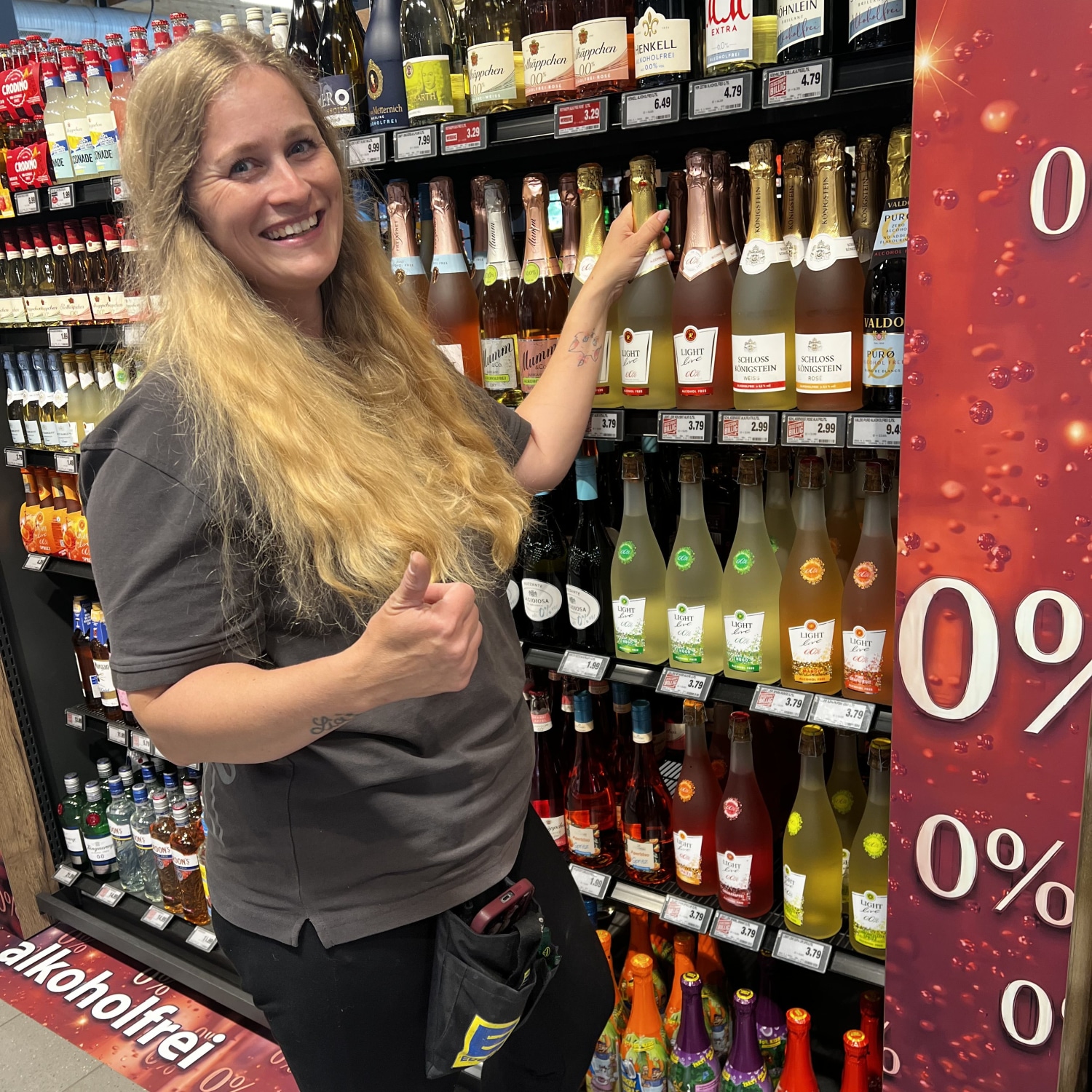 stellvertretene Marktleiterin Marina Olmes vor Wein-/ Sekt-Regal