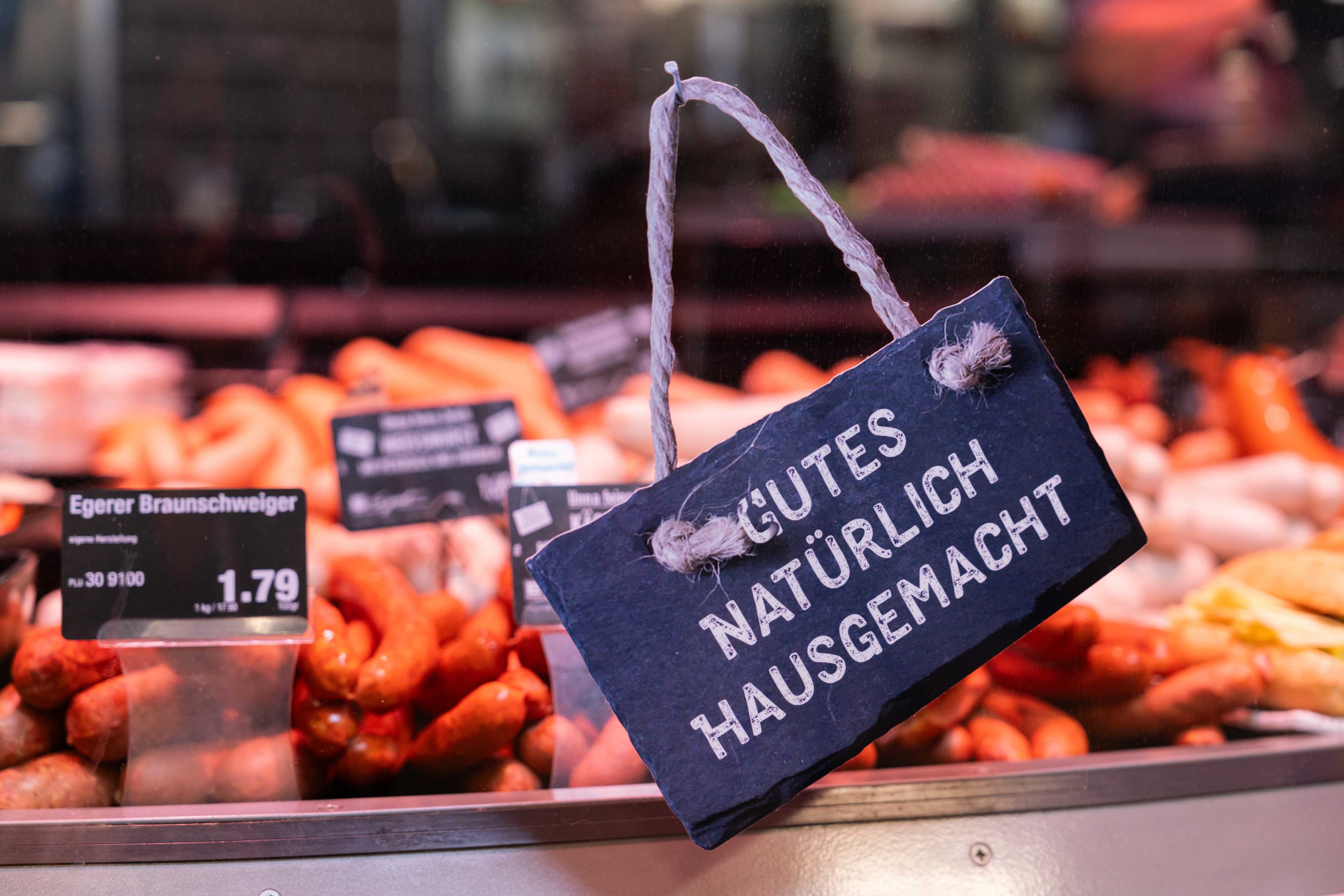 Ein Schild an der Fleischtheke eines EDEKA-Marktes auf dem steht: "Gutes natürlich hausgemacht"
