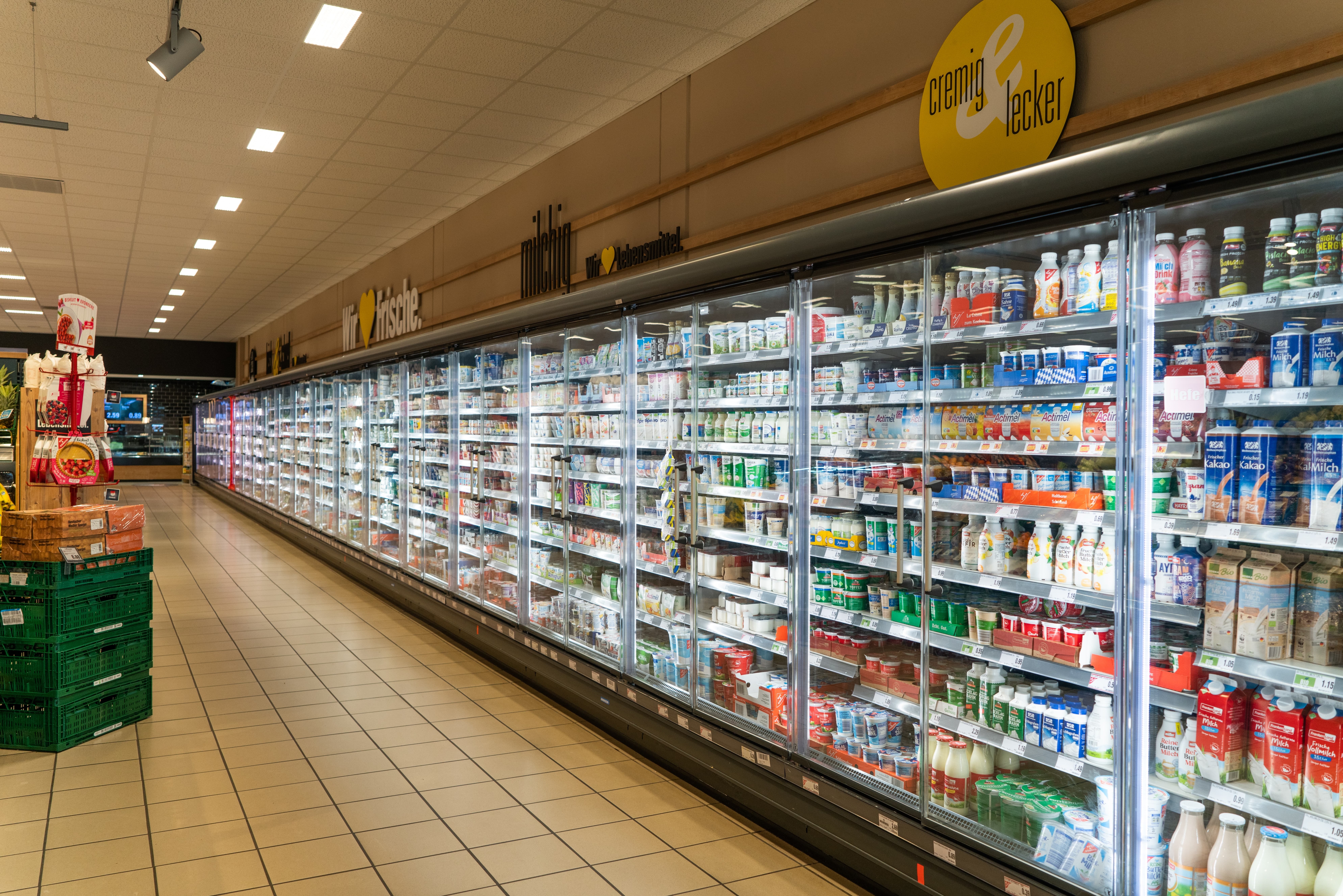Ein langes Kühlregal mit Glastüren in einem Edeka-Markt.