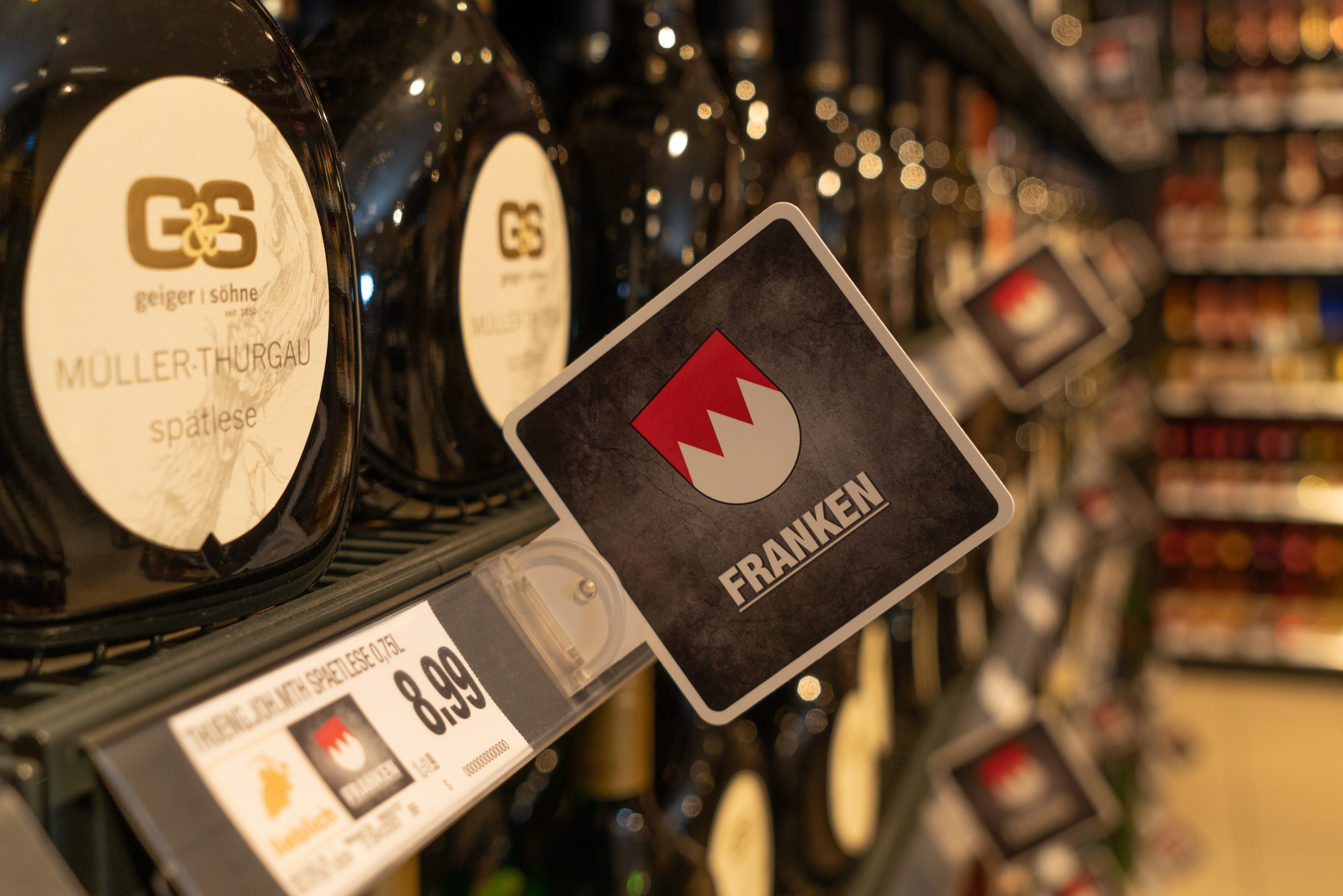 Nahaufnahme eines Regals mit regionalem Wein aus Franken.