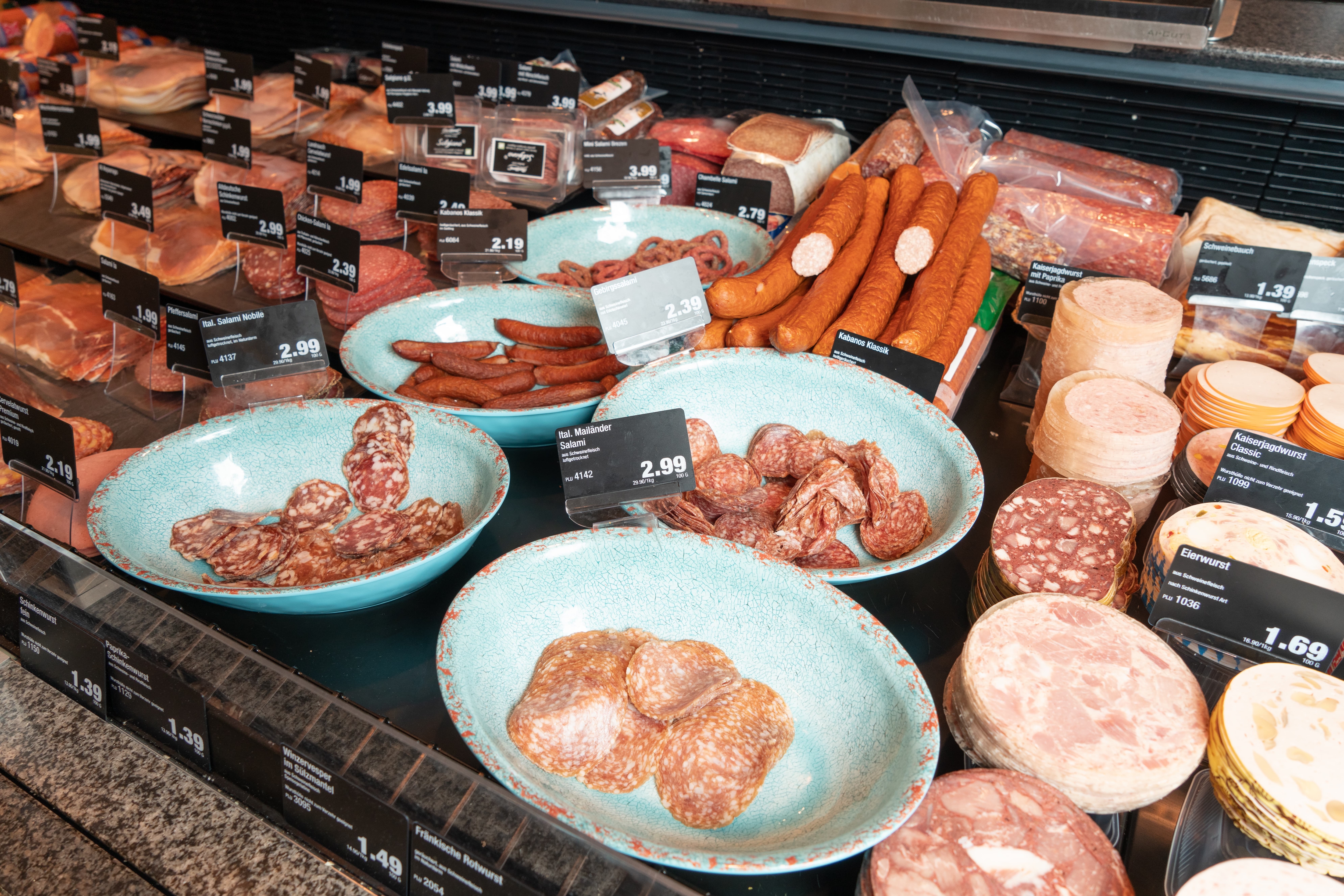 Verschiedene Arten Wurst in der Auslage einer Frischetheke eines Edeka-Marktes.