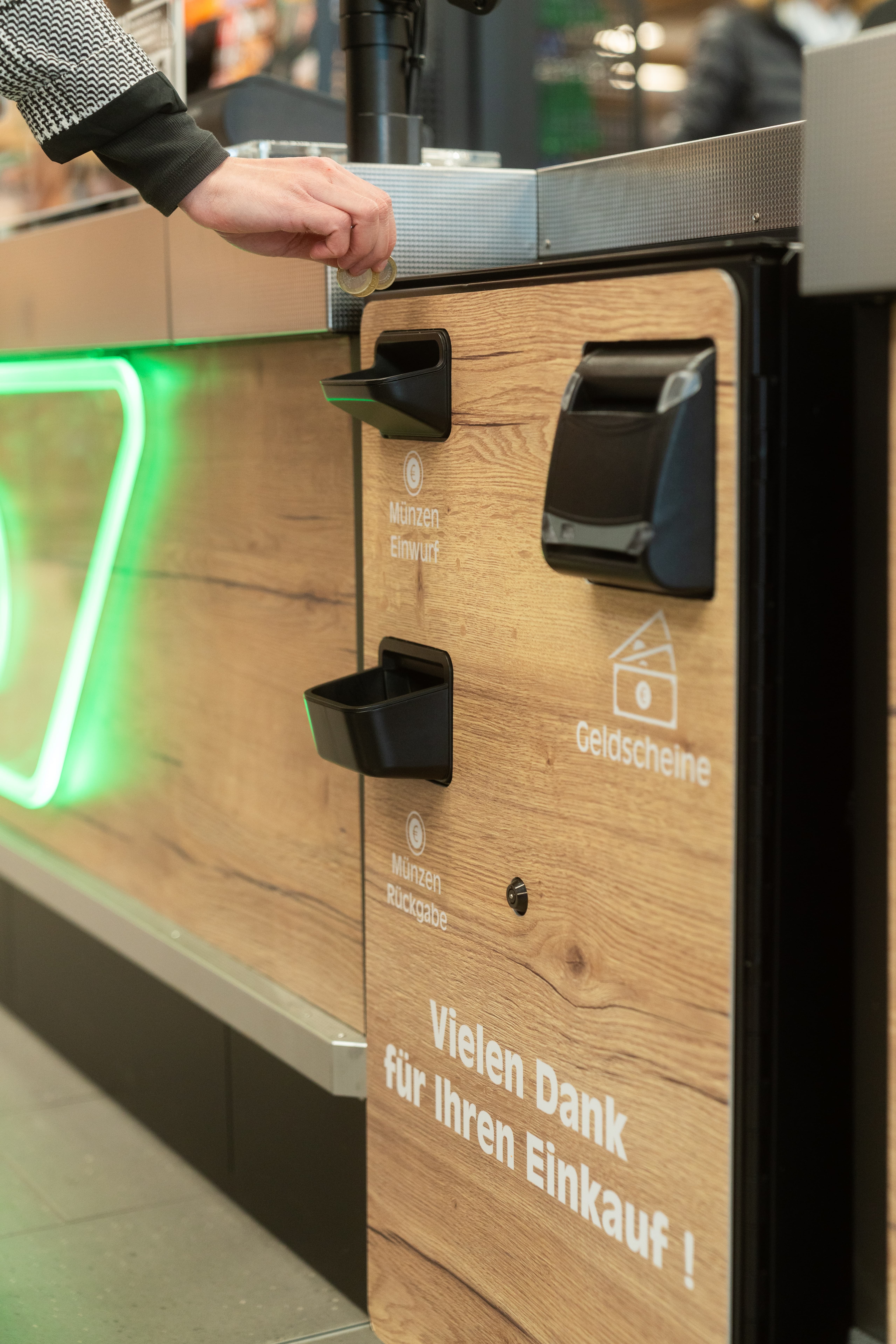 Münzeinwurf und Geldscheineingabe an einer Selbstbedienungskasse.