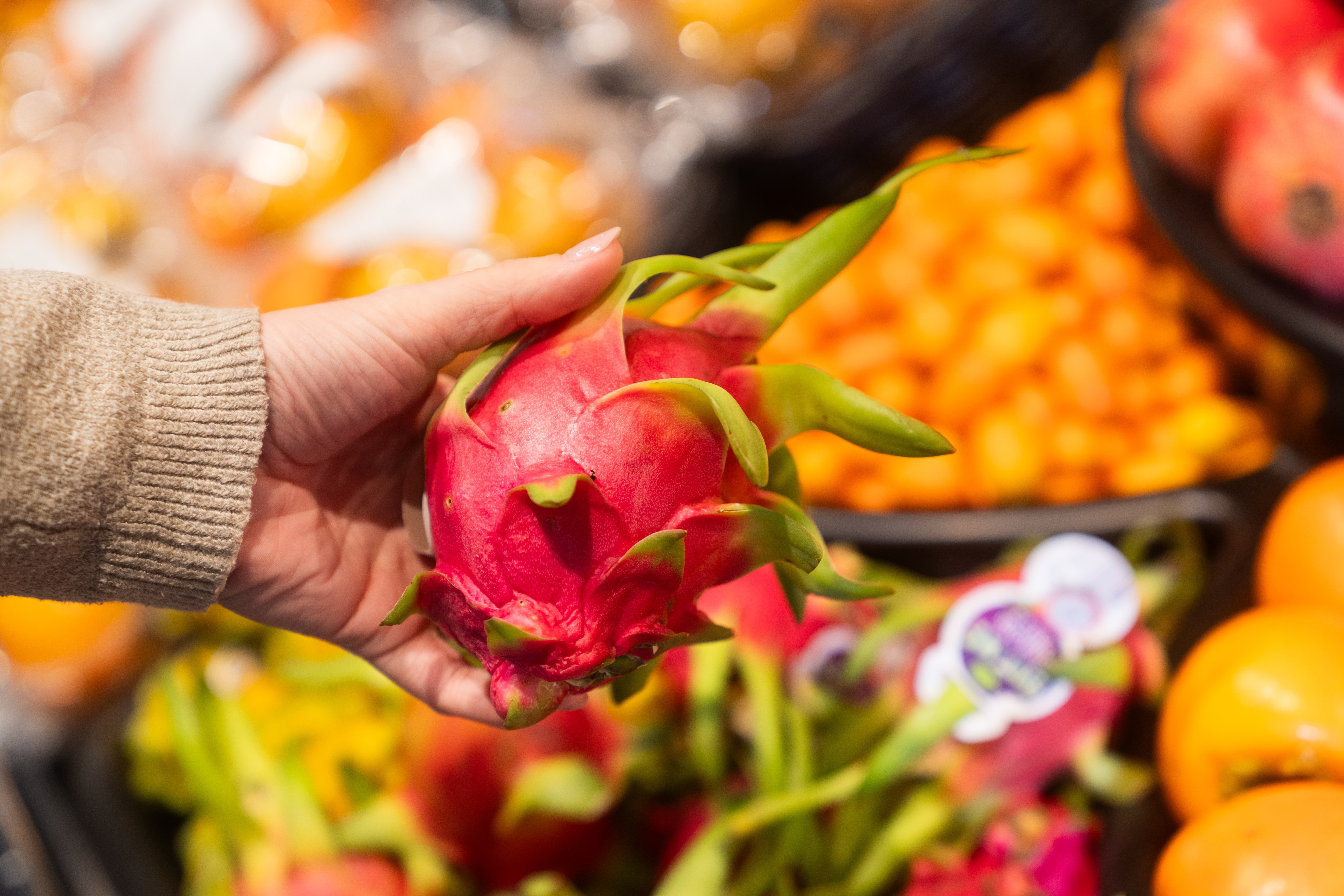 Eine rote Drachenfrucht mit grünen Spitzen.