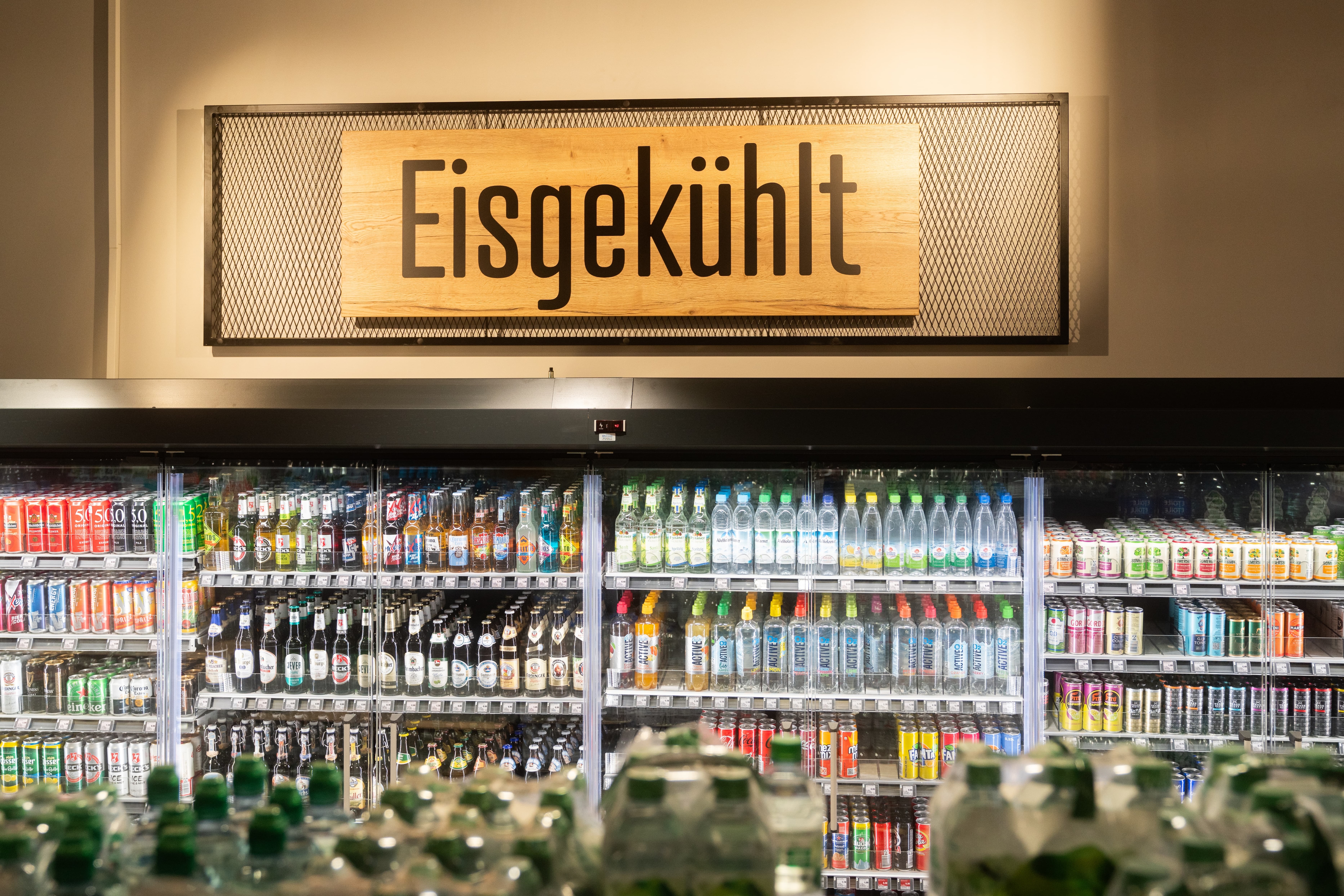 Getränkekühlschränke mit Bier, Wasser und Limonaden. Darüber steht: Eisgekühlt.