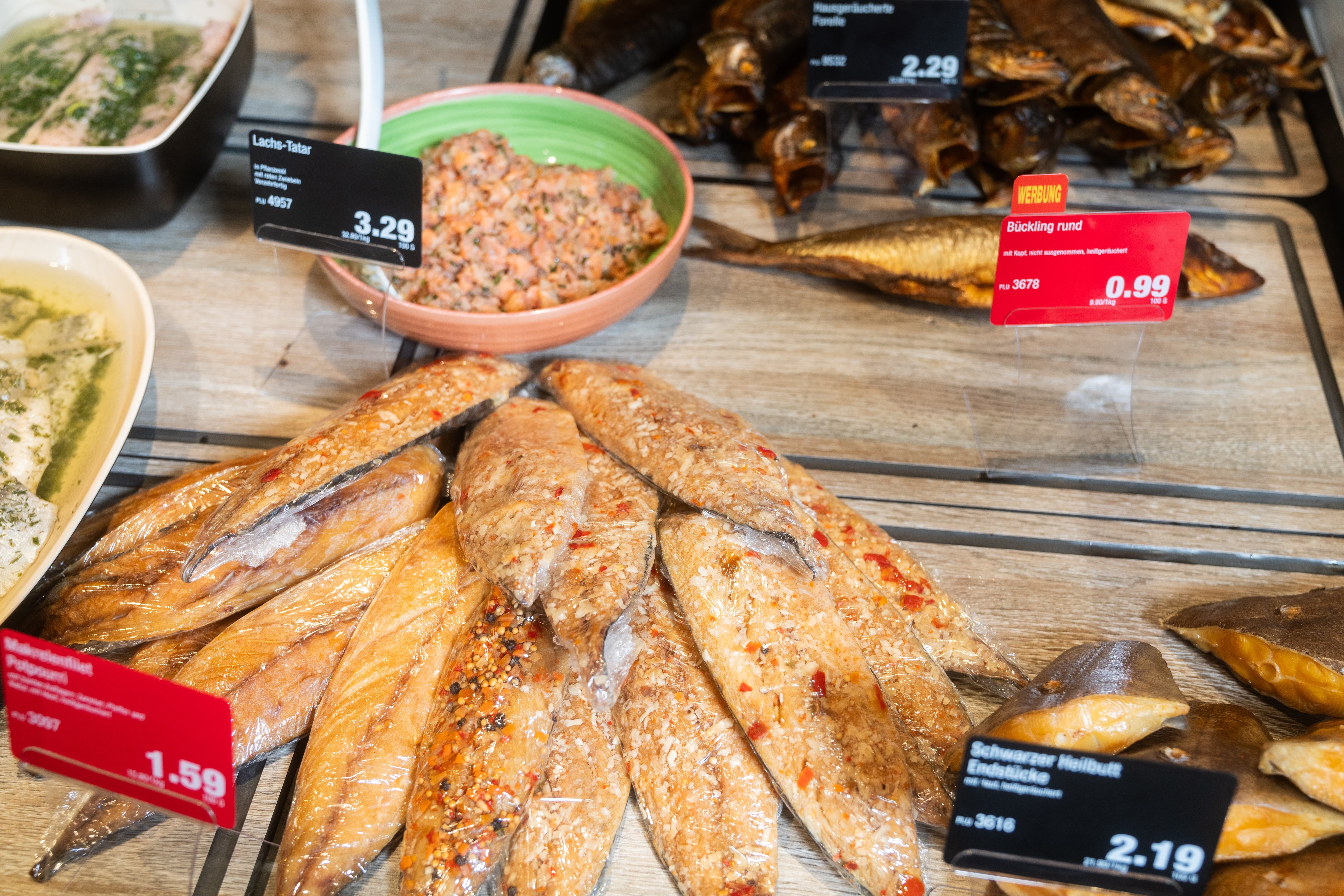 Verschiedene Sorten Räucherfisch mit Preisschildern.