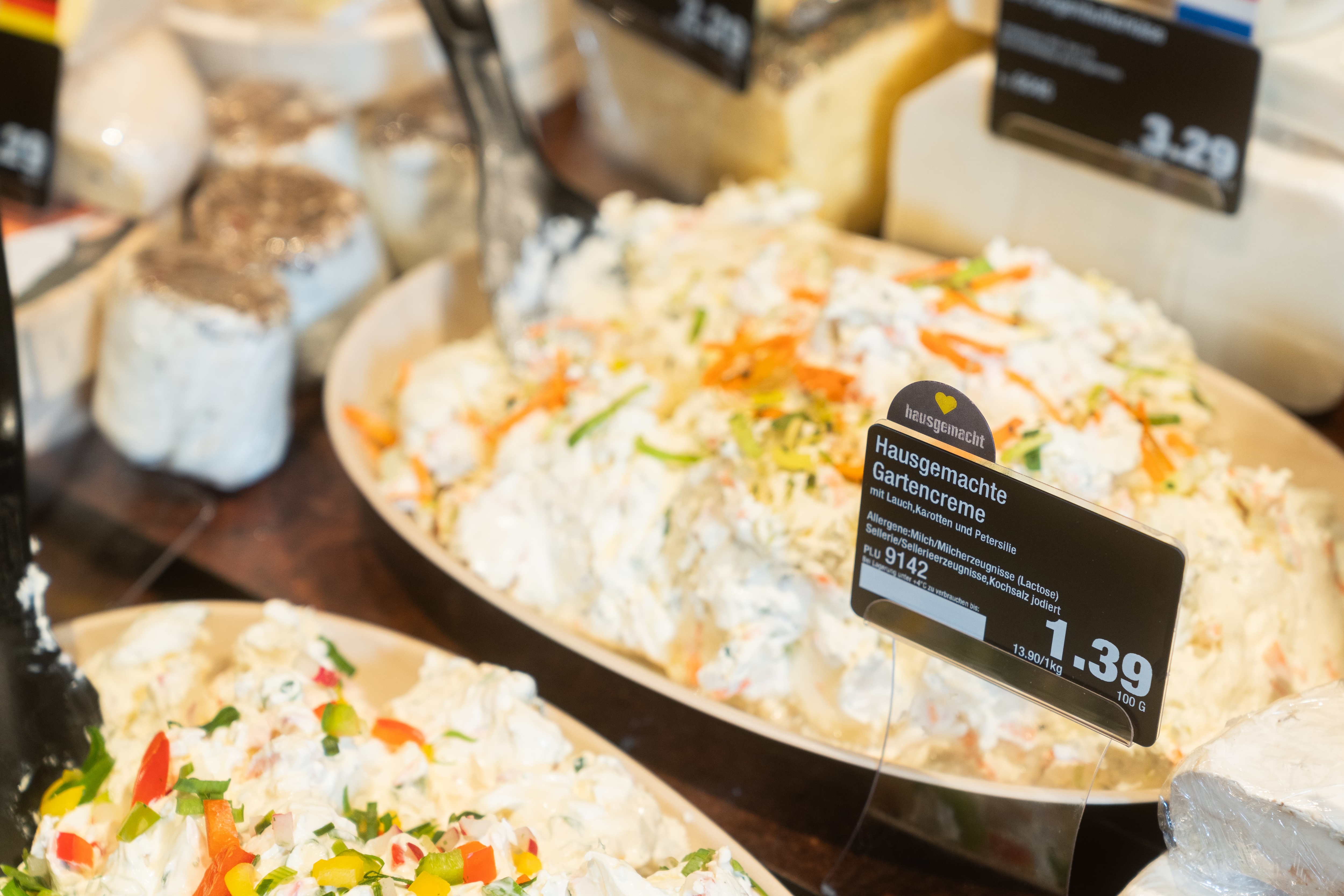 Eine Schüssel mit einem weißen Aufstrich. Auf dem Preisschild steht Hausgemachte Gartencreme.