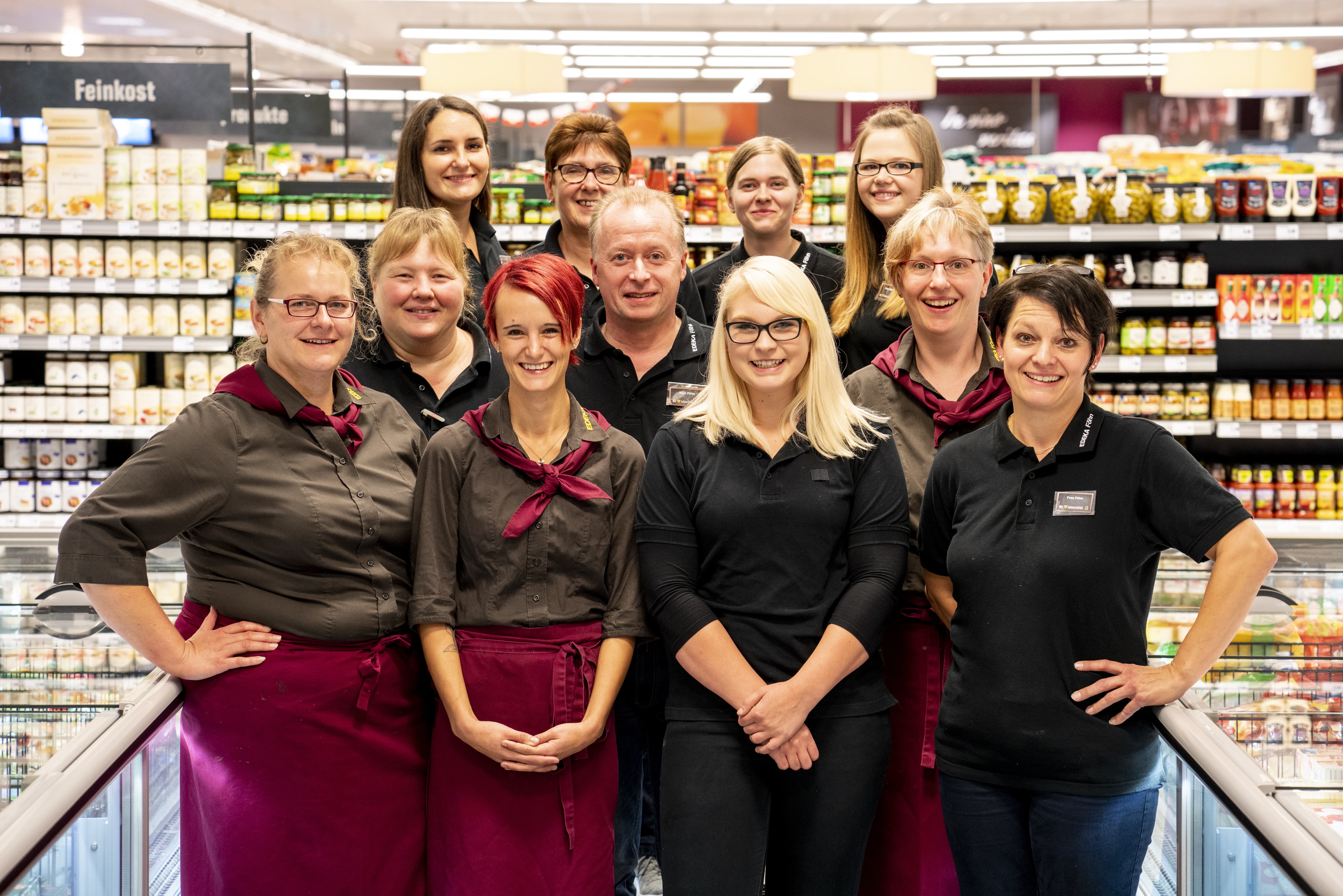 Gruppenfoto des Teams dieses EDEKA-Markts, aufgenommen im Gang im Tiefkühlbereich.