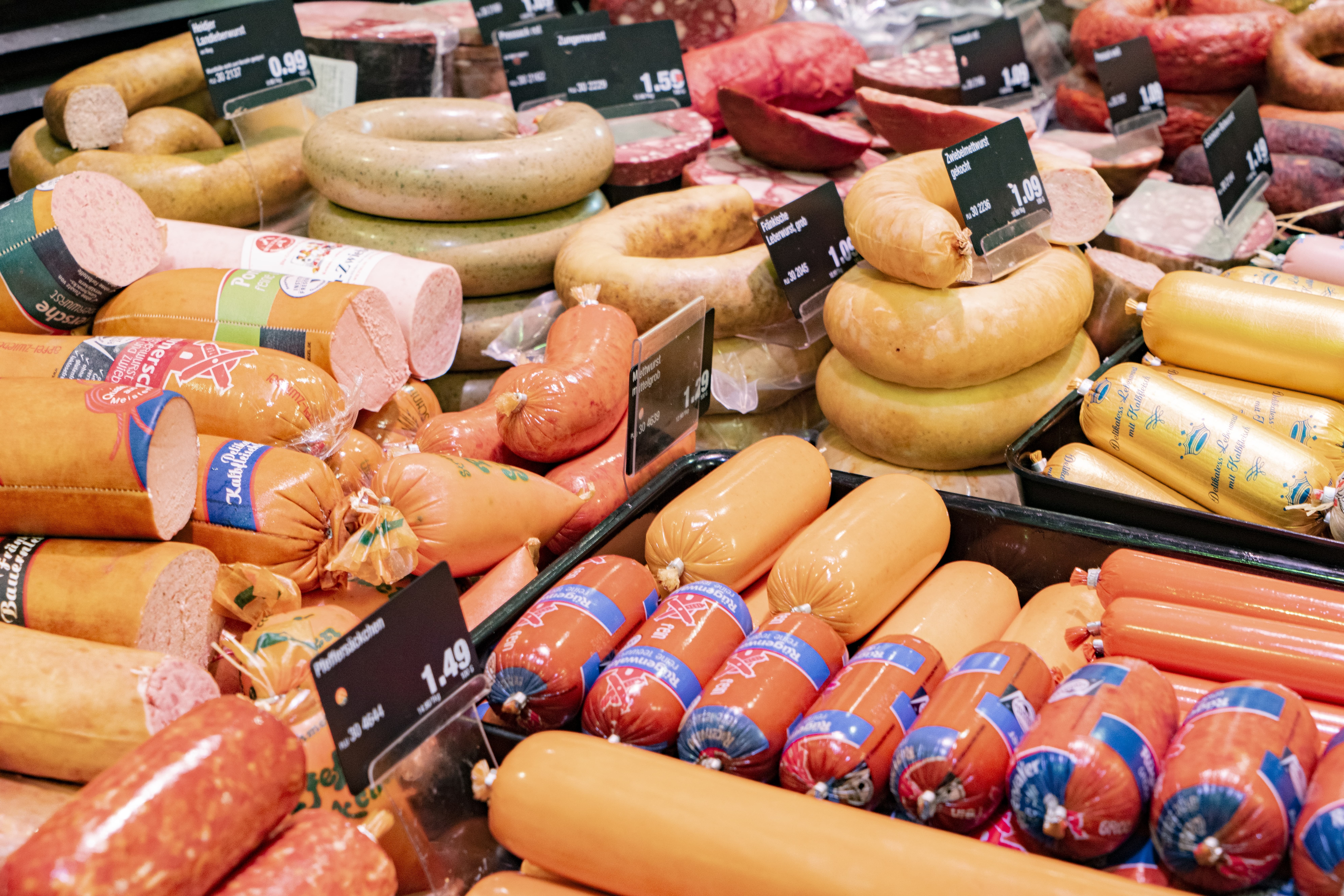 Wurst- und Aufschnittauslage mit unterschiedlichen Produkten und Preisschildern.