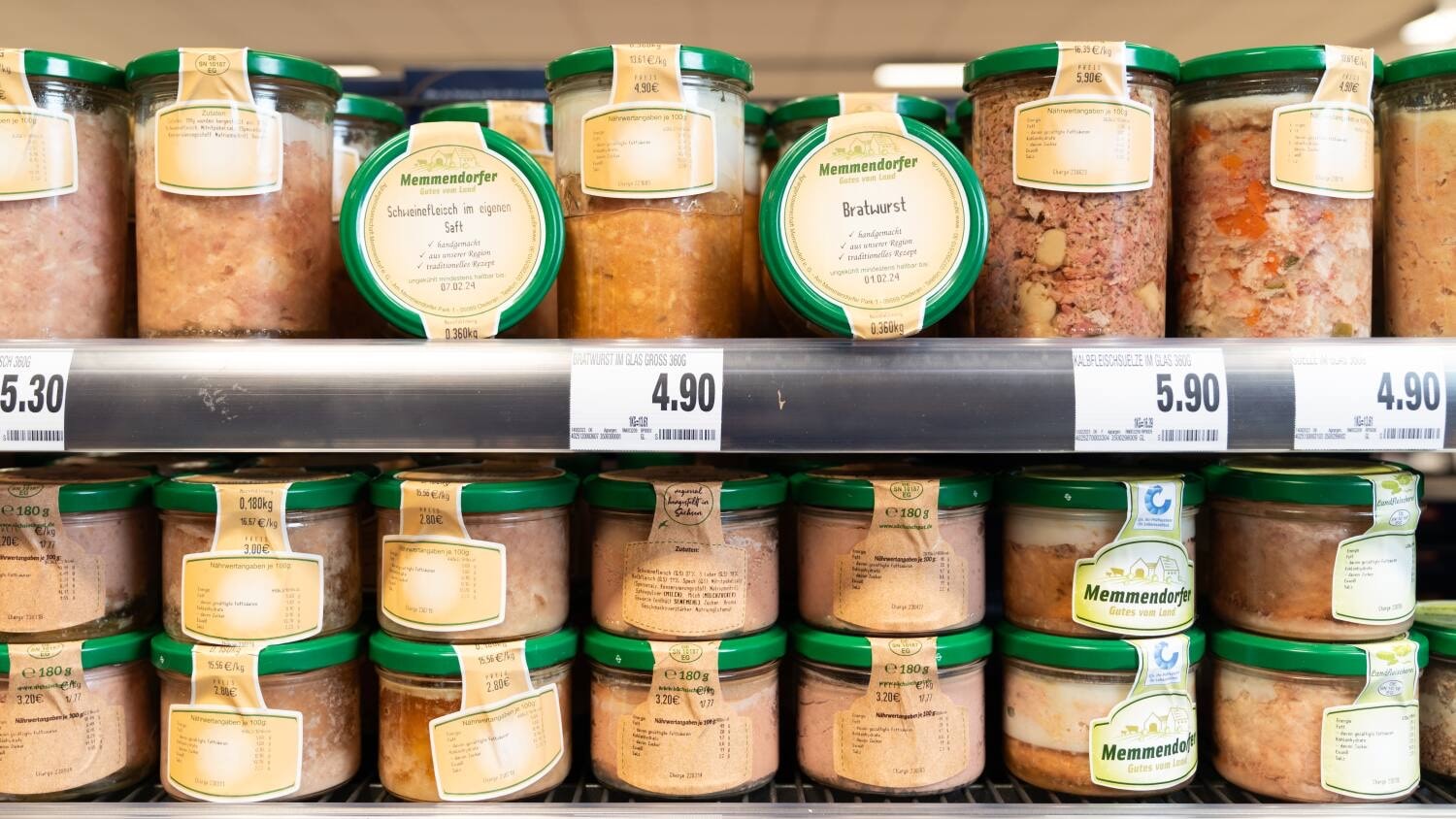 Ein Regal mit Gläsern voller Wurstprodukte.