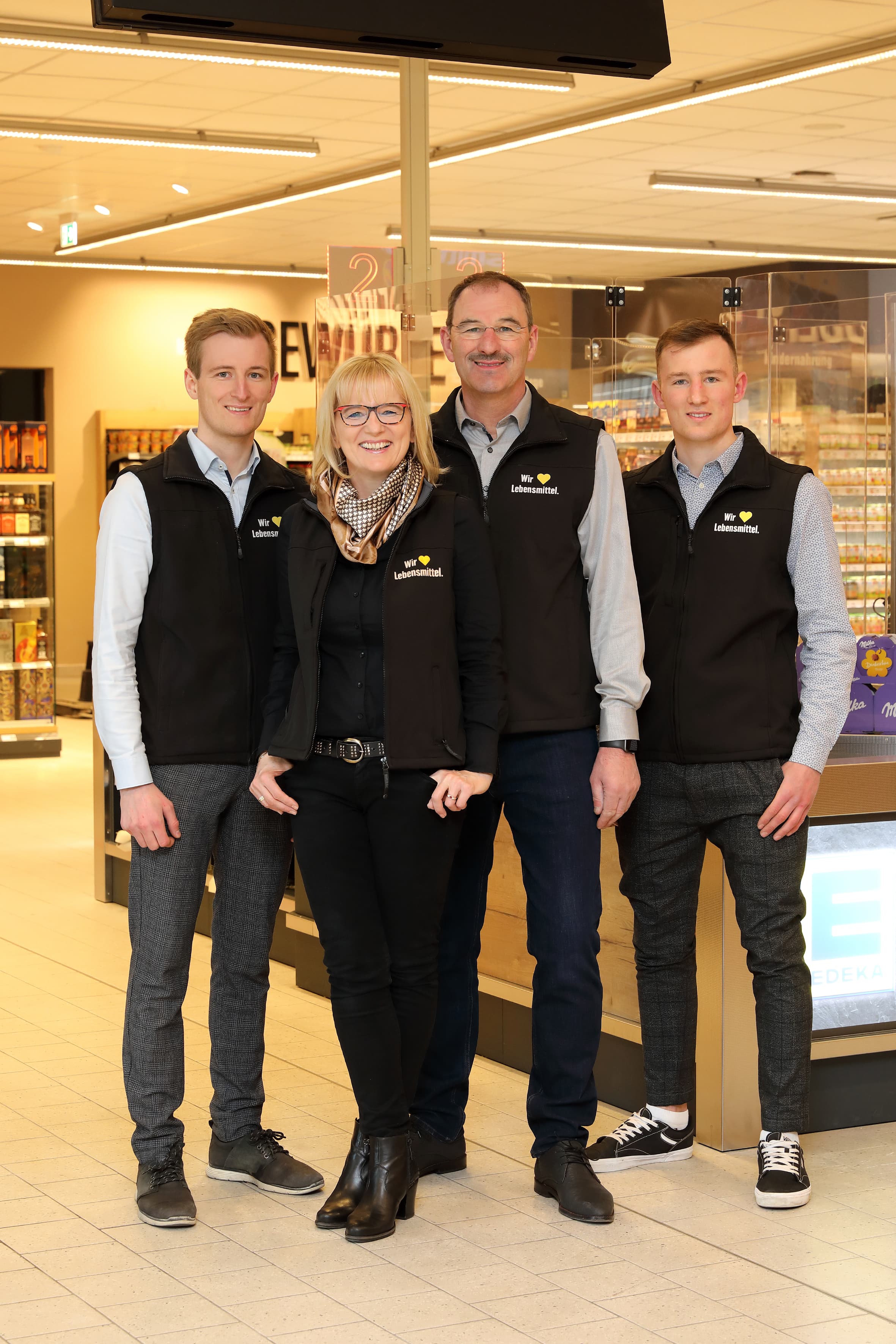 Die Inhaber-Familie eines Edeka-Marktes im Kassenbereich.