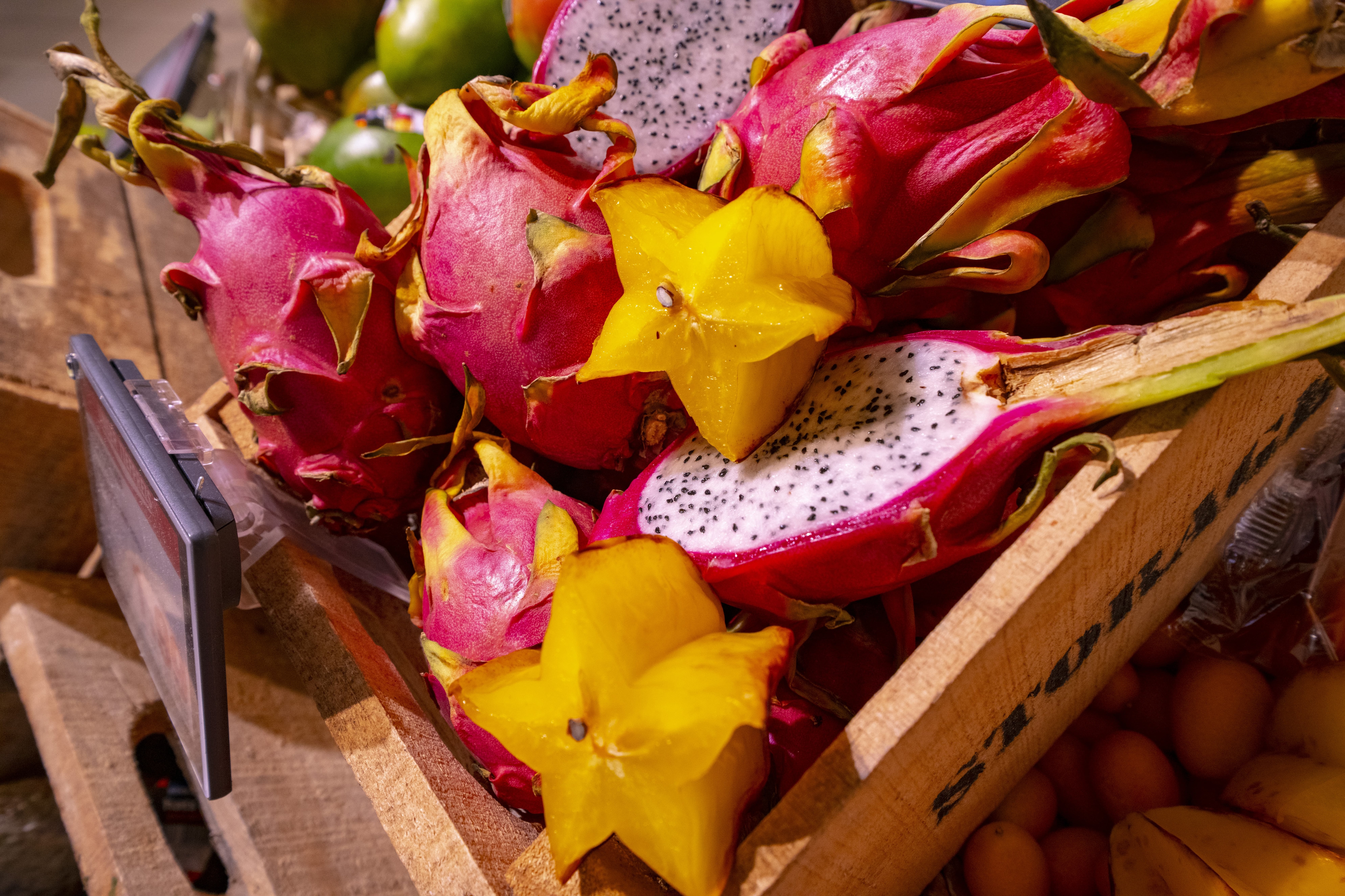 Drachenfrucht, teils dekorativ zugeschnitten, in der Obst- und Gemüseabteilung eines EDEKA Markts.