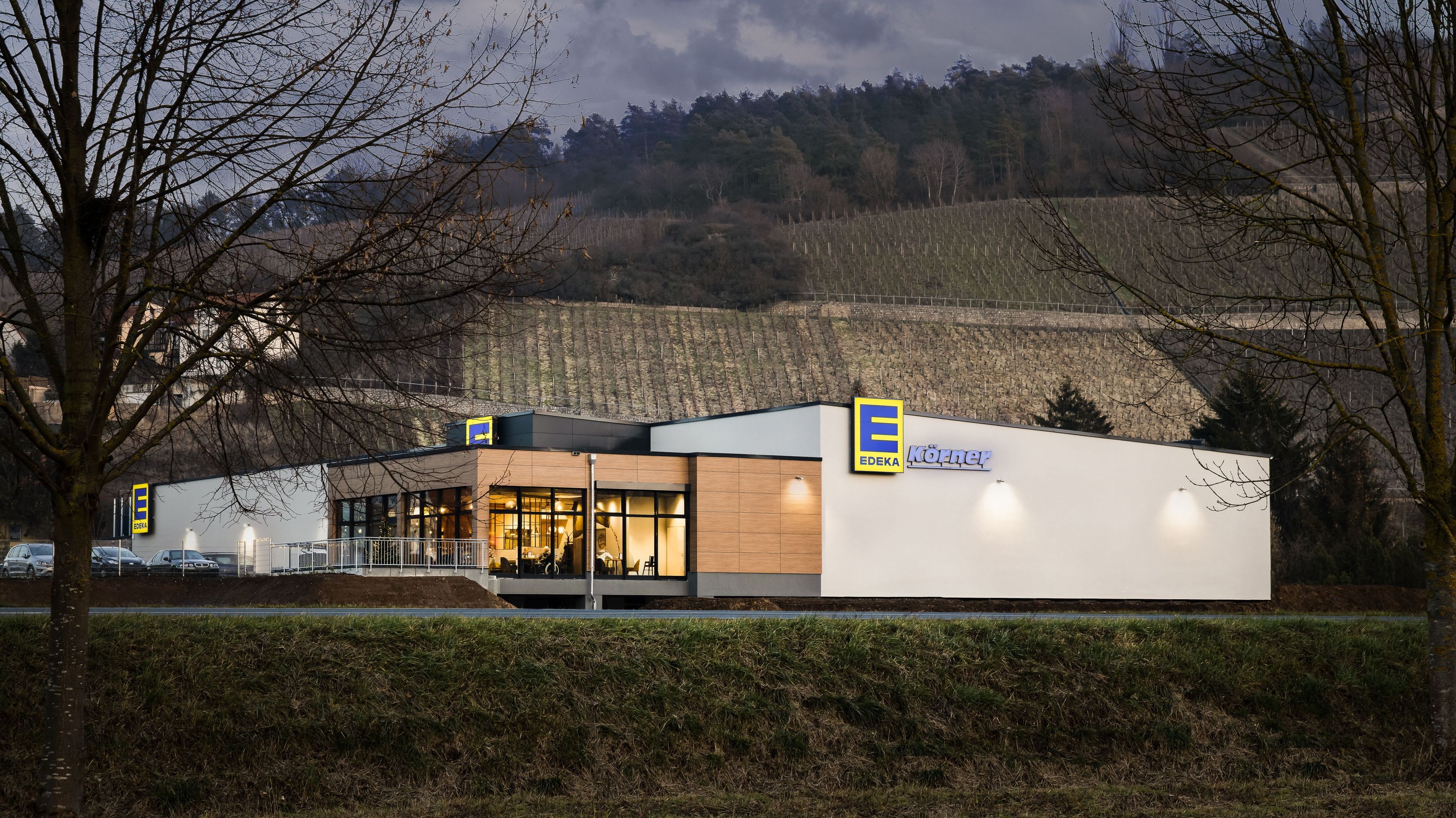 Außenansicht des Marktes Körner in Randersacker mit dahinterliegenden Weinbergen.